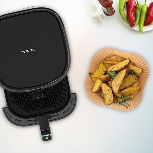 Fekete Cecotec légkeveréses fritőz nyitott fedéllel és krumplival a tányéron.