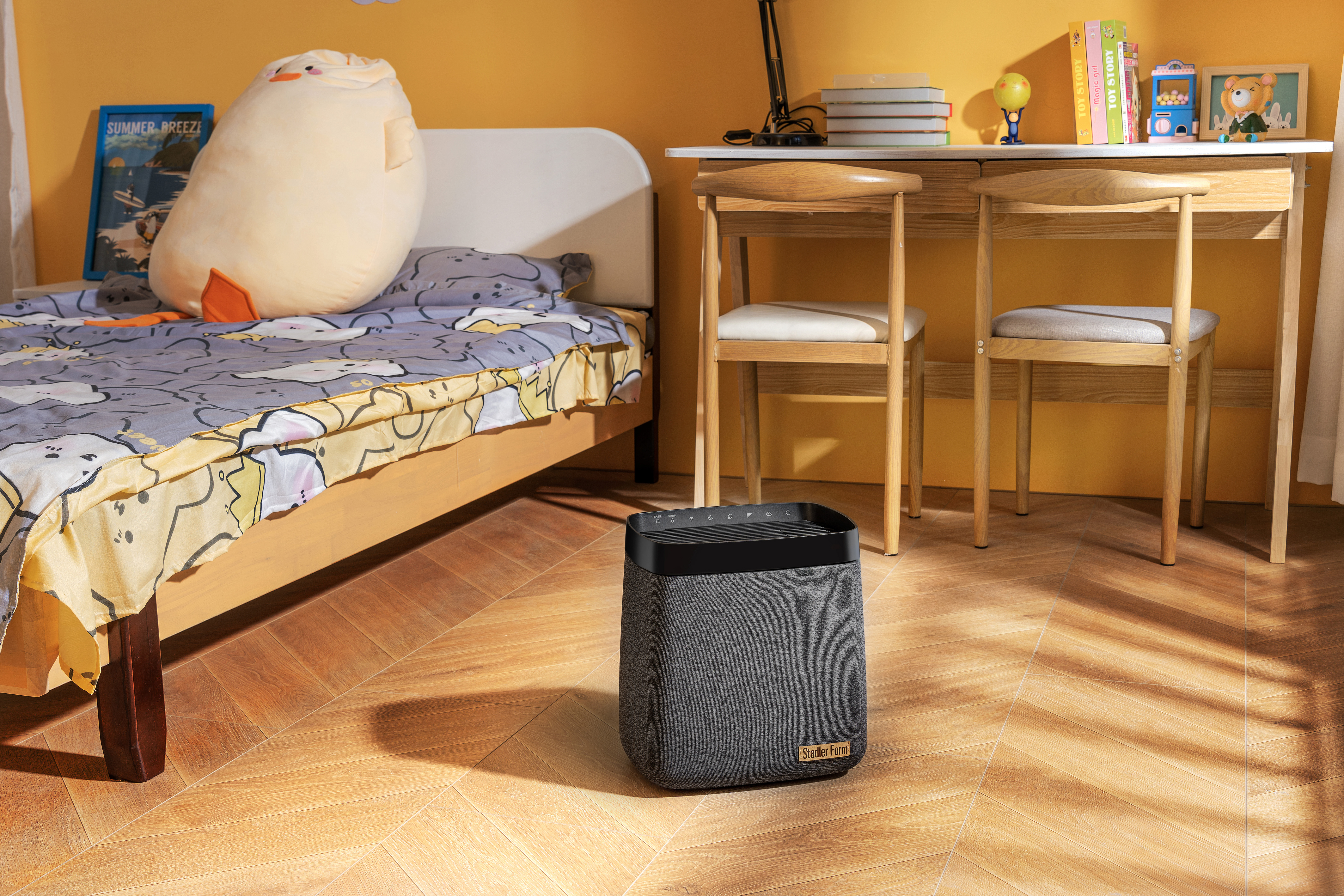 Schlafzimmer mit Luftreiniger und Bett. Schreibtisch mit Büchern und Spielzeug.