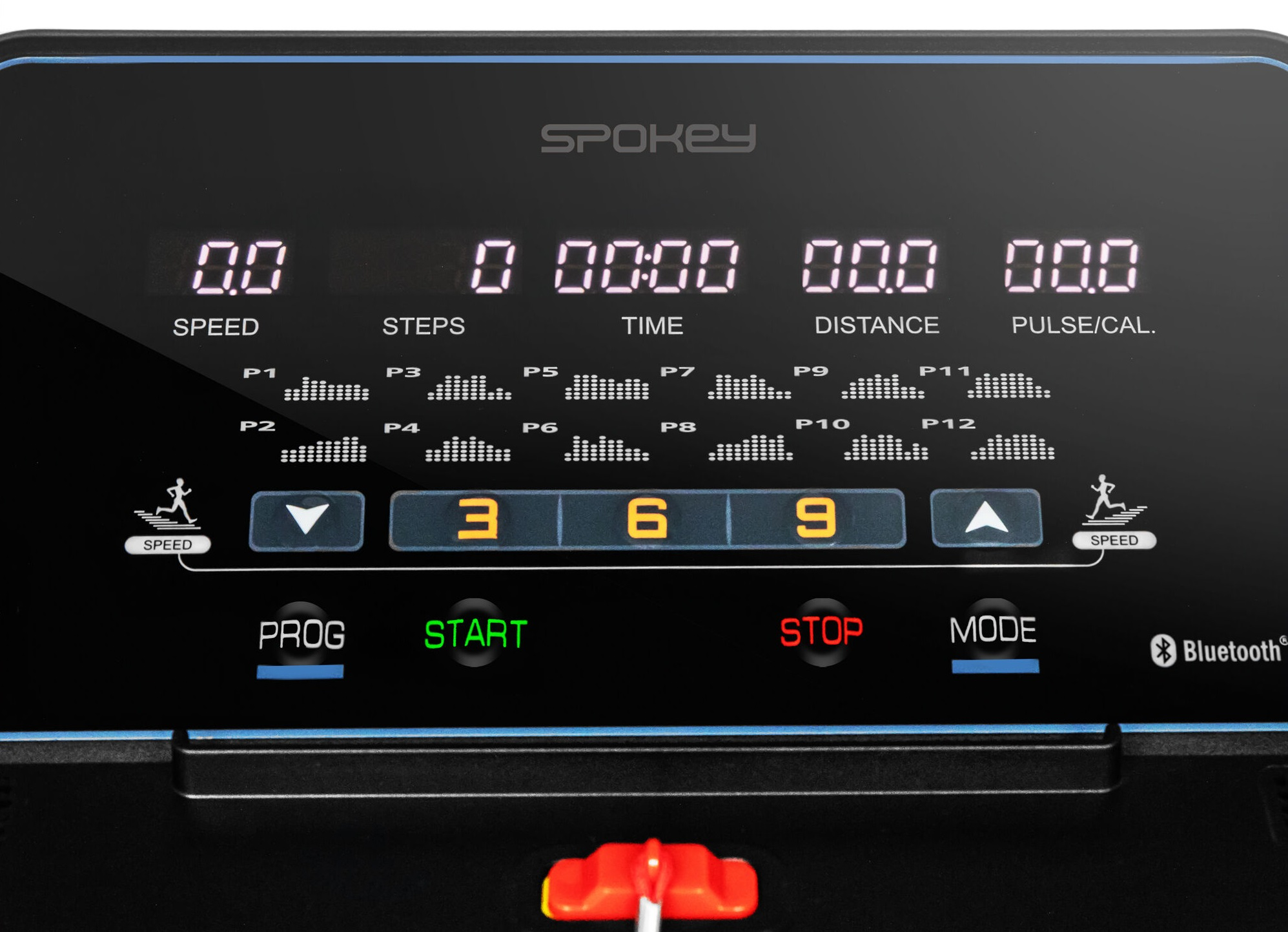 Zbliżenie wyświetlacza bieżni. Pokazuje prędkość, czas, dystans i inne dane treningowe.