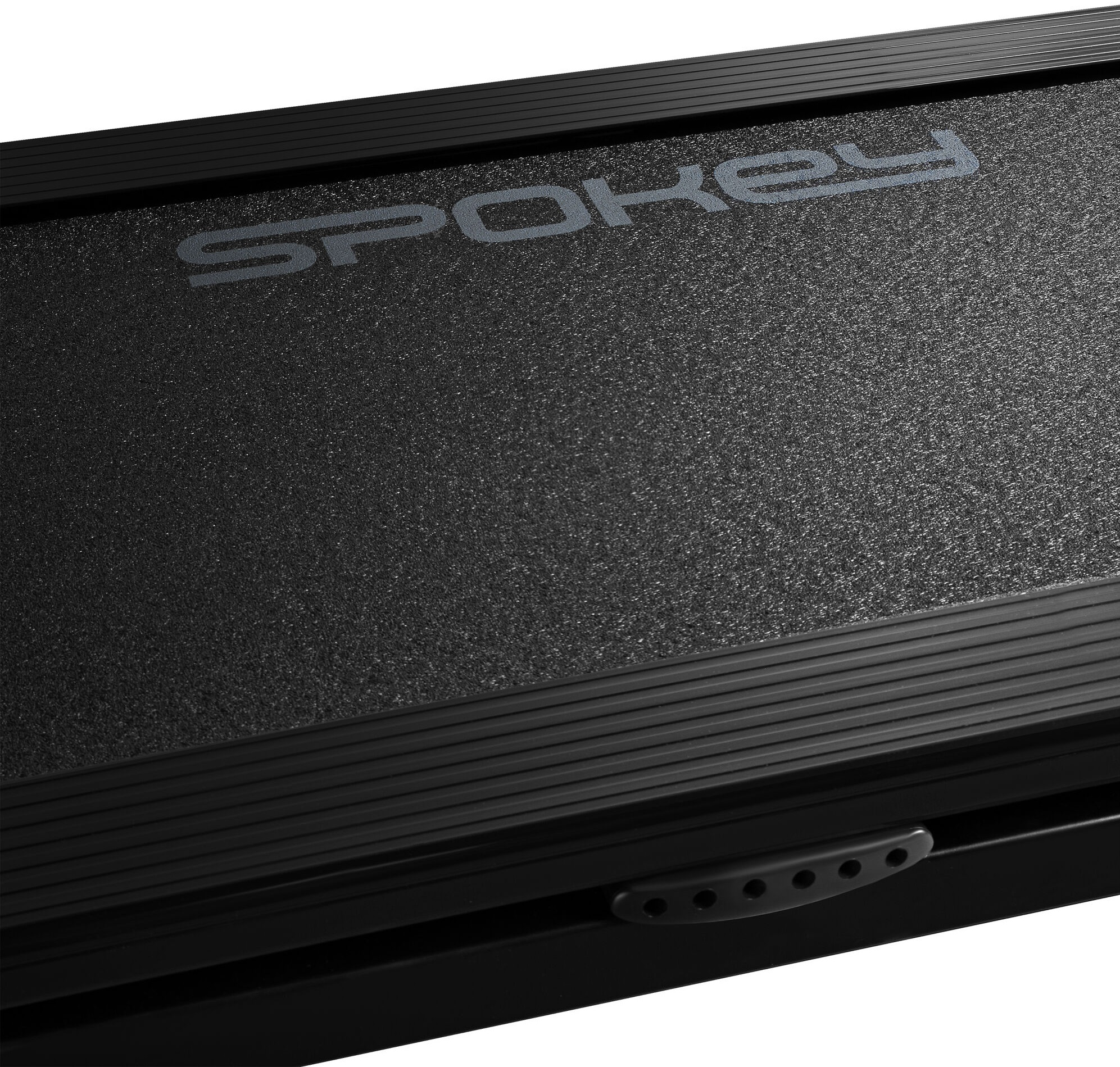 Zbliżenie na czarną powierzchnię bieżni Spokey z uchwytem.