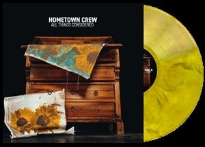 Ein Holzkleiderschrank mit einer Sonnenblumen-Decke und einer Schallplatte.