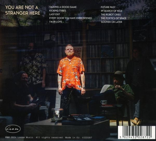 Albumcover mit einer Band, die herumsitzt, Text und einem Barcode. Braune und weiße Farben.