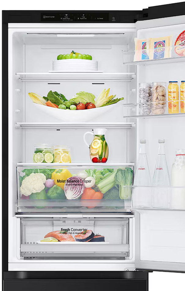 Otwarty wnętrze lodówki. Półki z jedzeniem, warzywami i napojami.