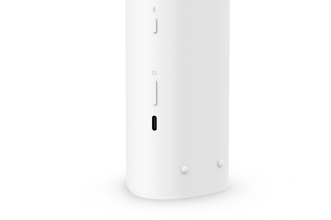 Fehér hangszóró gombokkal. Bluetooth és bekapcsoló gombok, valamint egy USB-C port. Fehér háttér.