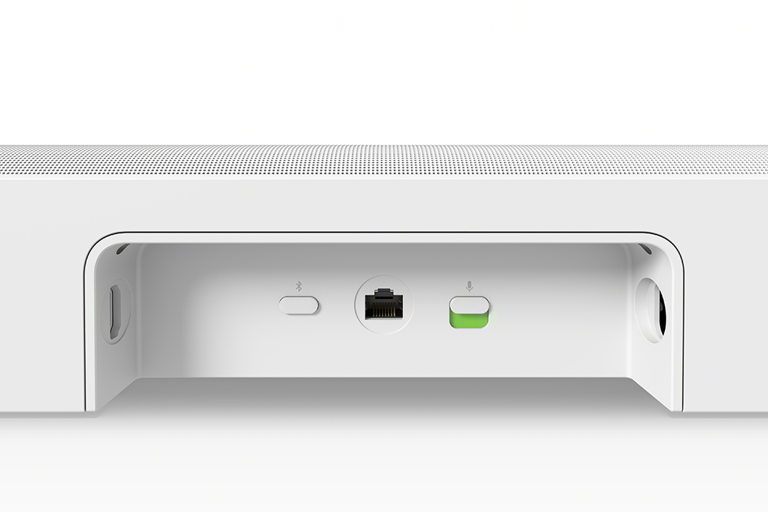 Fehér soundbar, süllyesztett résszel, amely portokat és gombokat tartalmaz, beleértve egy Ethernet portot és a mikrofon gombot.