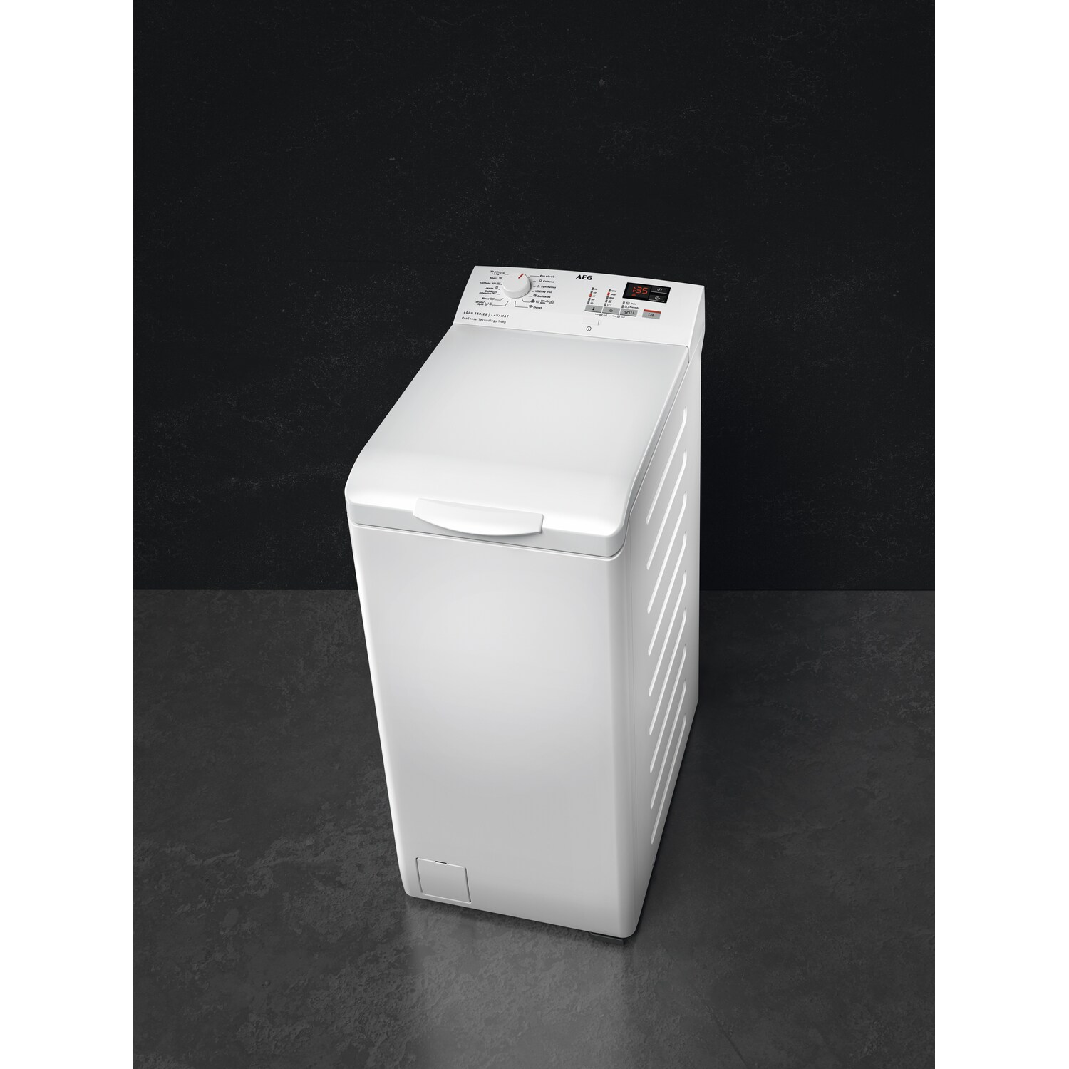 White top-load washing machine on a dark surface. The machine has a control panel at the top.