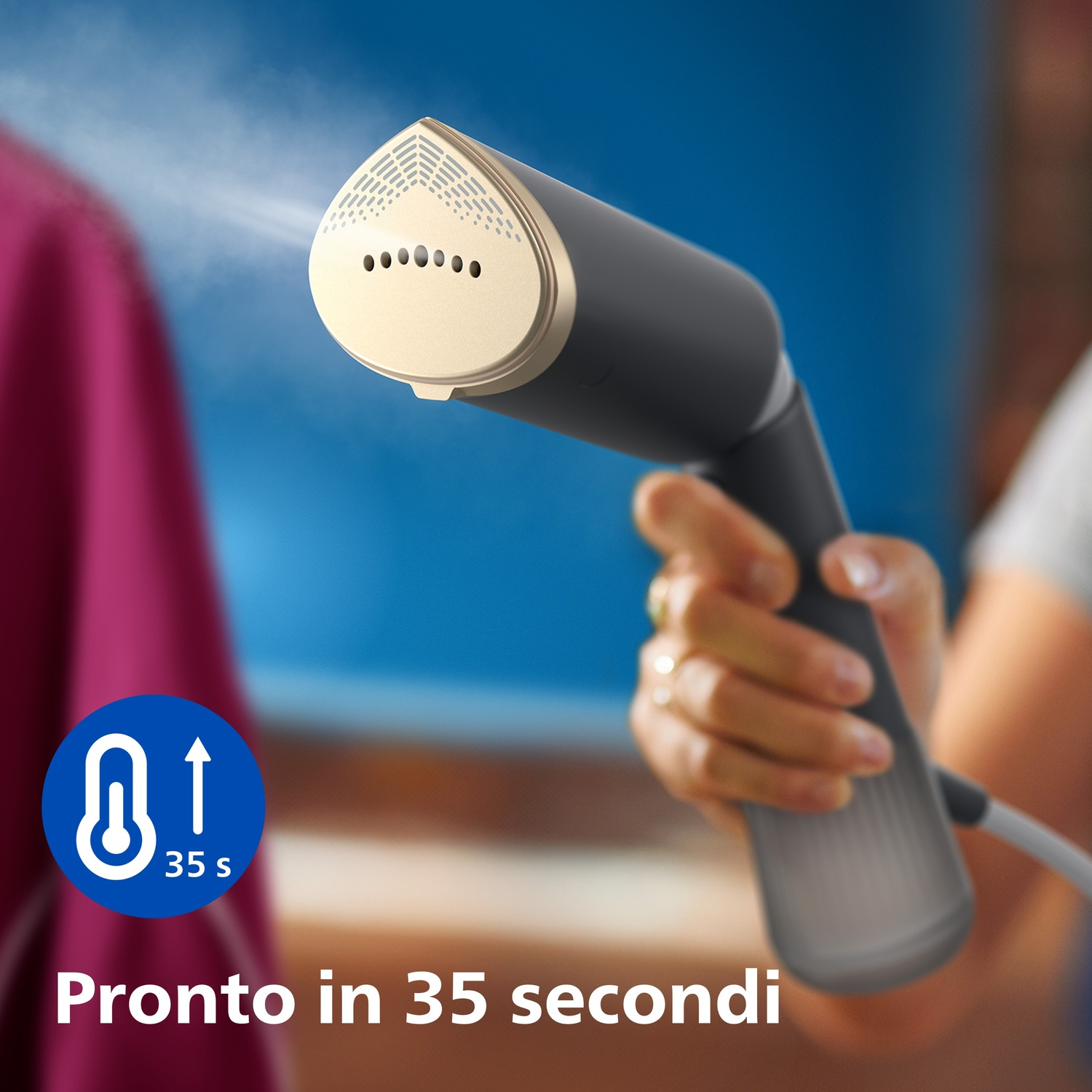 Una mano tiene un vaporizzatore per indumenti grigio e beige con vapore che esce.