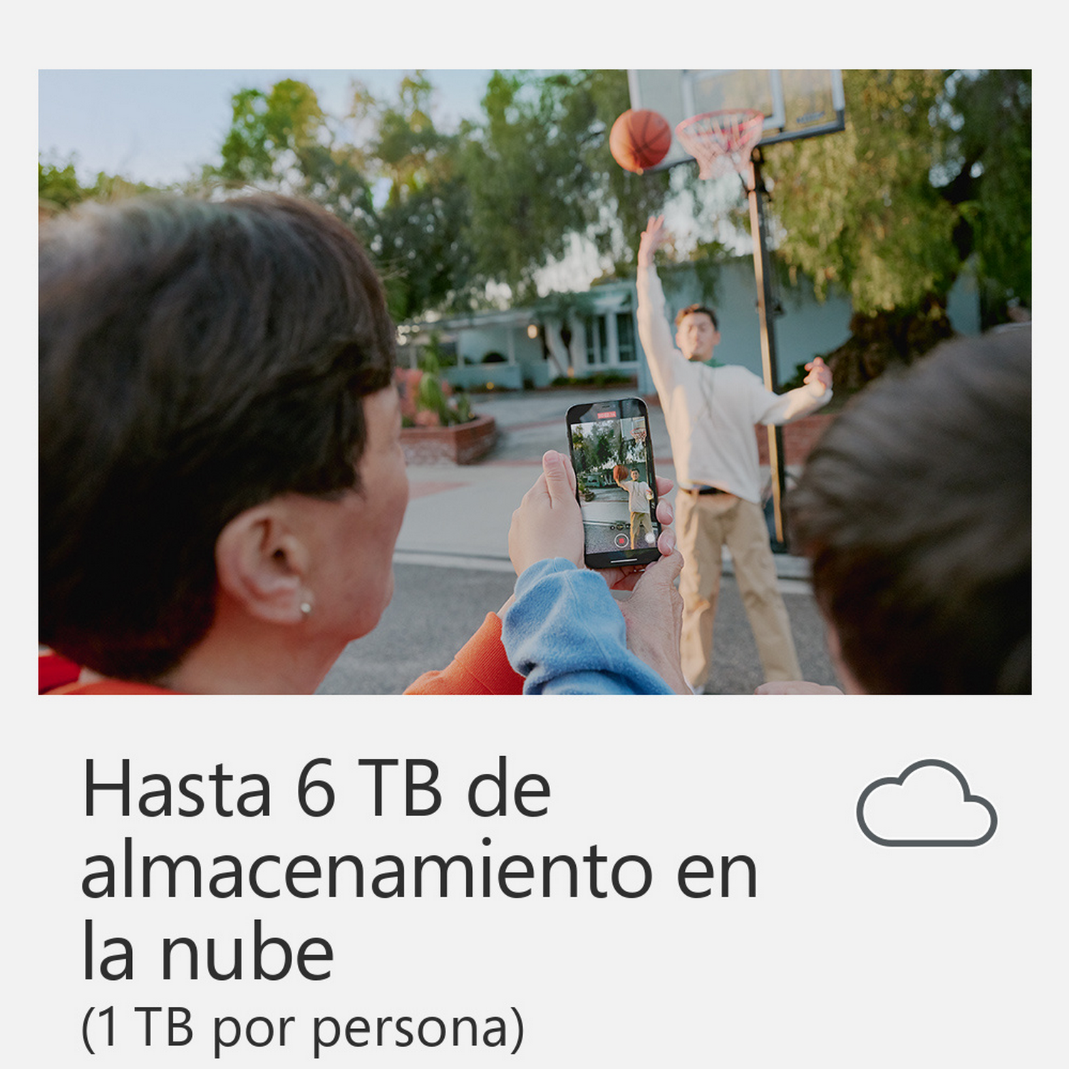 Gente filmando un partido de baloncesto con un teléfono, con el icono de la nube y texto sobre almacenamiento en la nube.