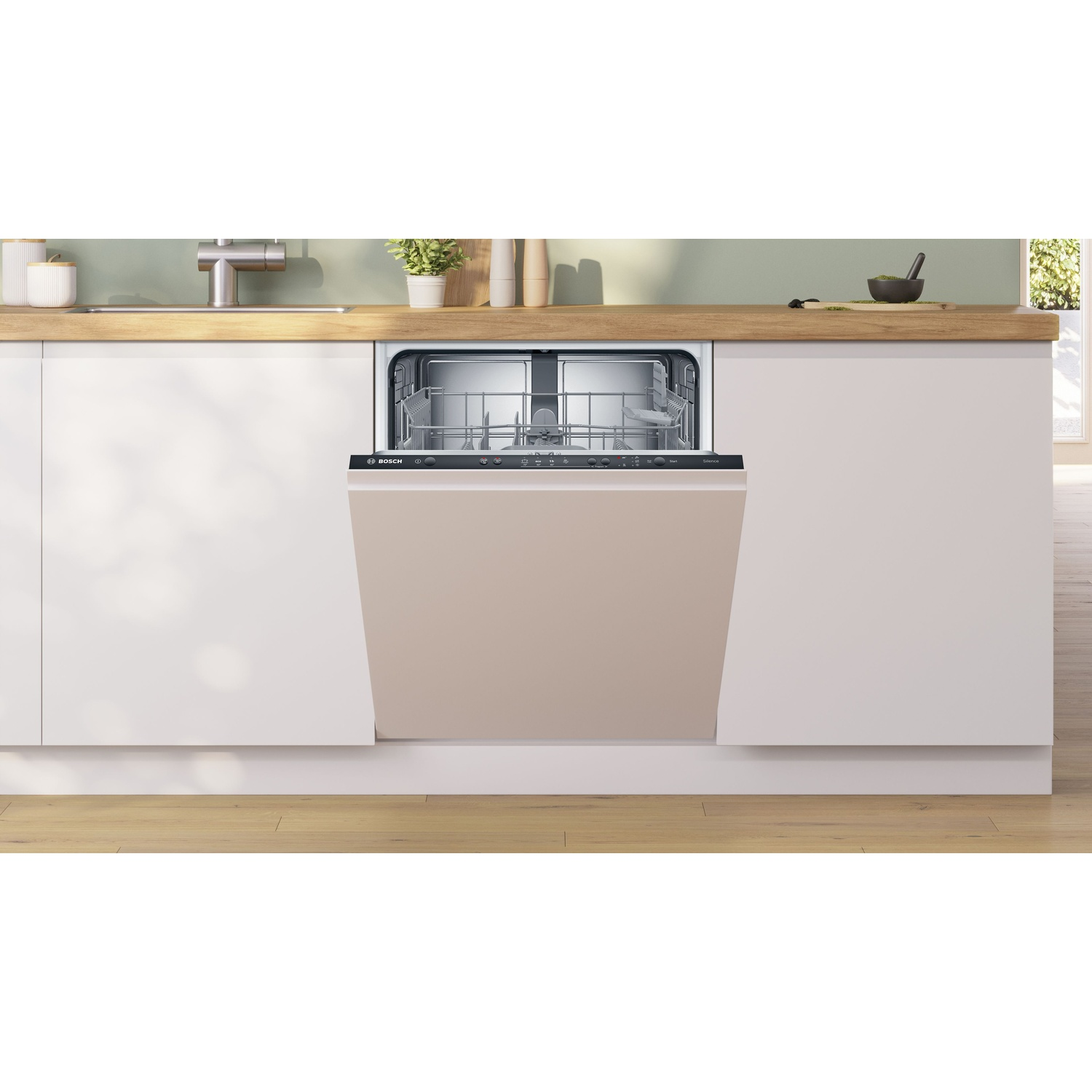 Lavastoviglie aperta, porta beige, mobili bianchi e piano di lavoro in legno.