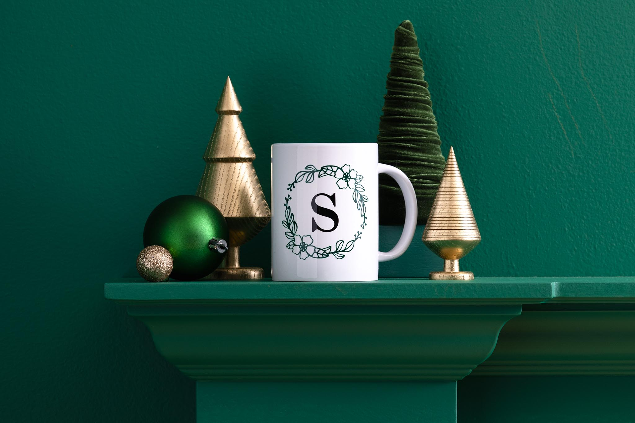 Weihnachtsdekoration auf einem Regal, einschließlich Tasse und Bäume.