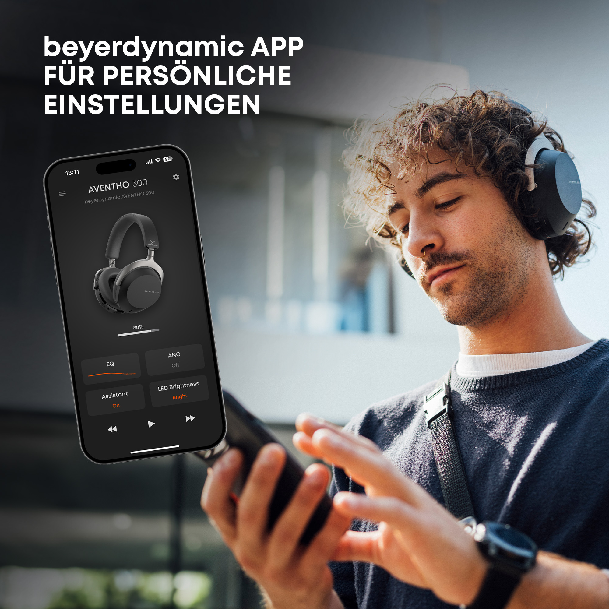 Ein Mann mit Kopfhörern schaut auf ein Telefon mit einer App.