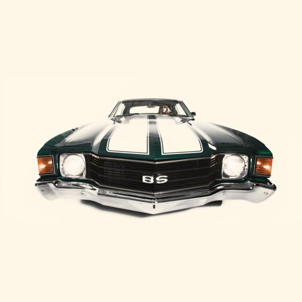 Dunkelgrüner Oldtimer mit weißen Streifen auf der Motorhaube und Chromgrill.
