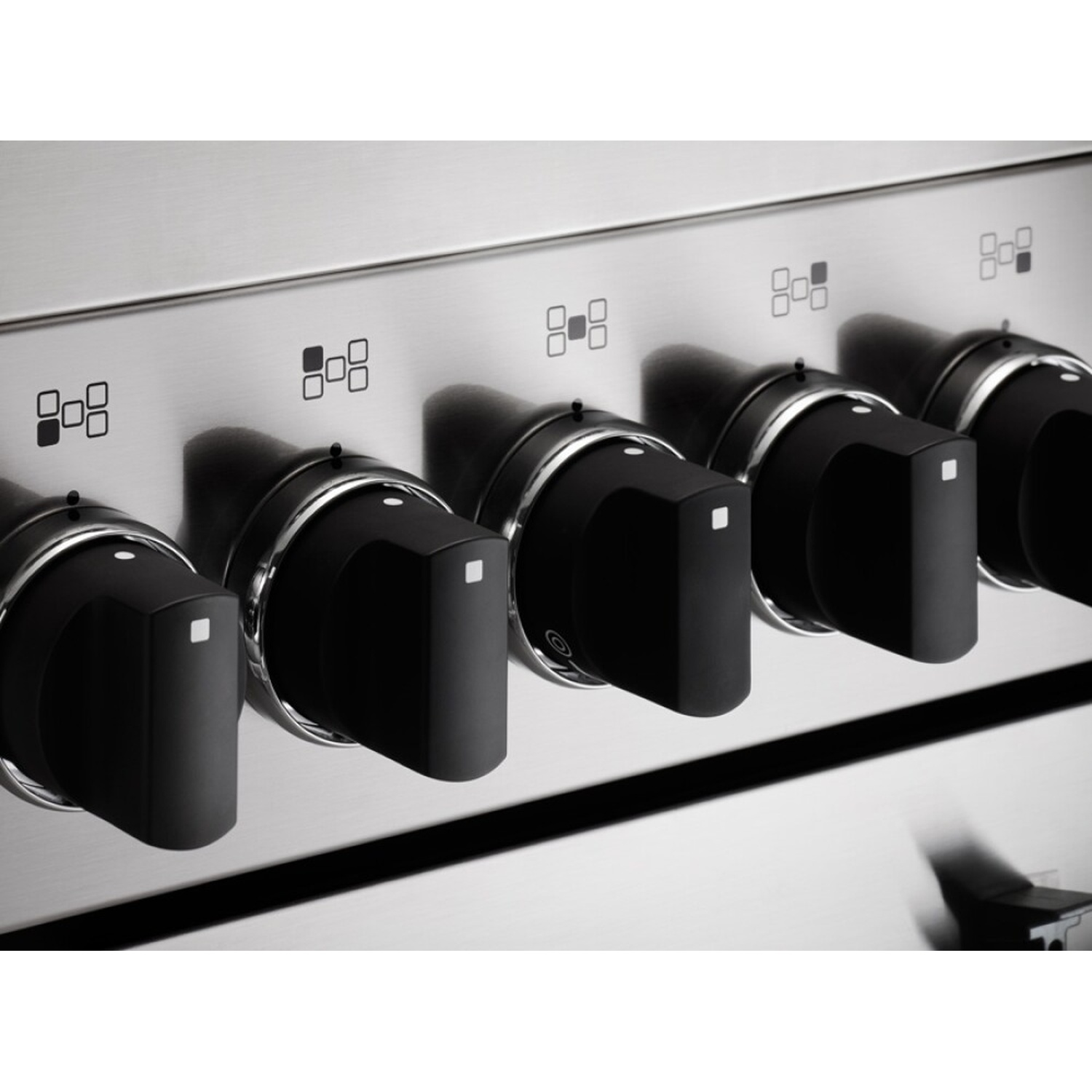 Primo piano di un piano cottura con manopole nere per controllare i bruciatori.