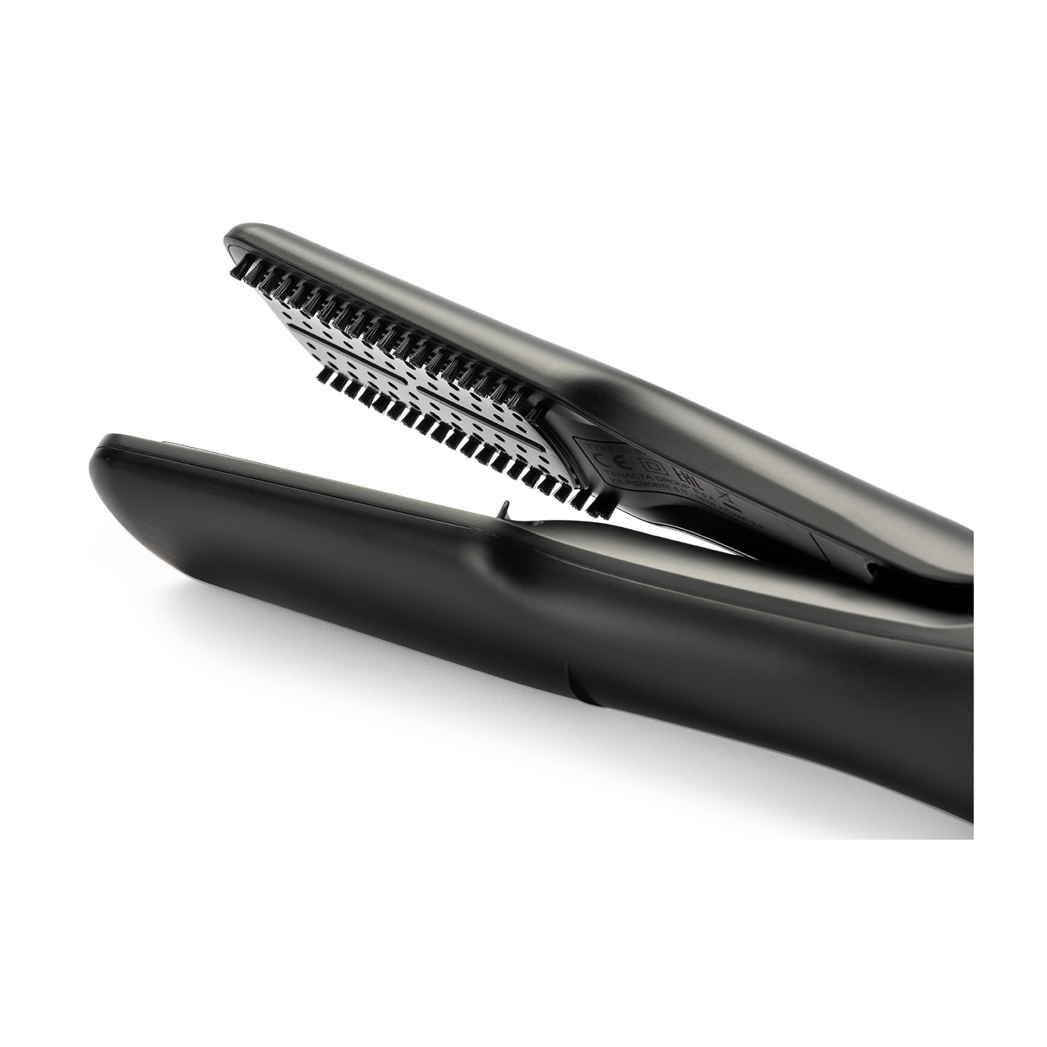 Piastra per capelli nera con piastre aperte, che mostrano strutture simili a denti. Sfondo bianco.