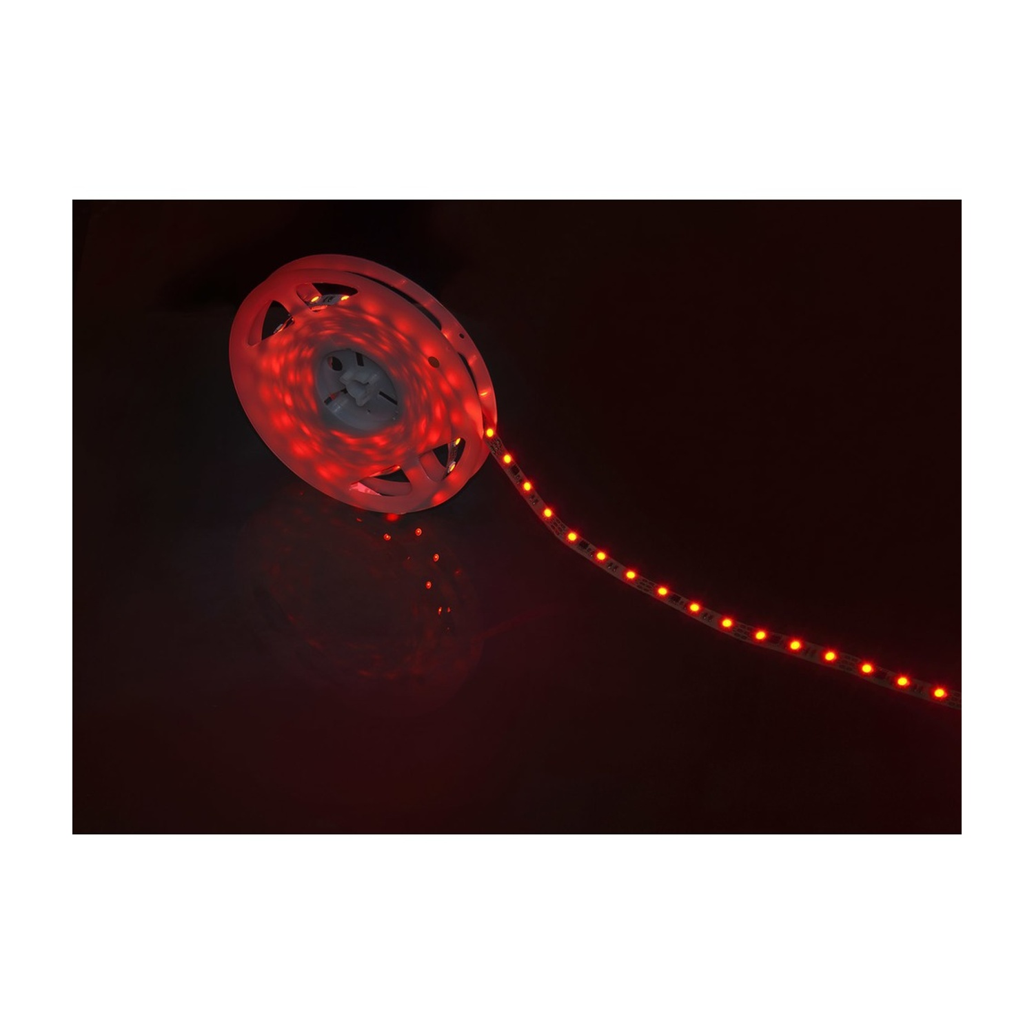 Un rotolo di strisce luminose a LED rosse. Le luci sono accese ed emettono luce rossa.