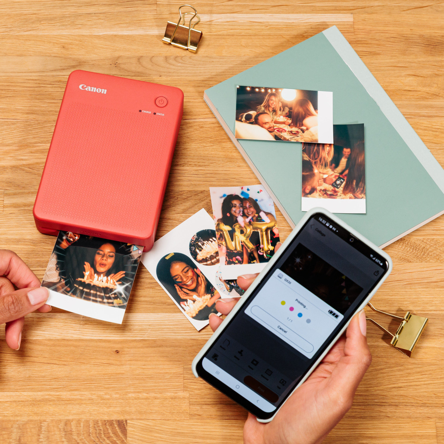 Canon printer en telefoon op houten tafel. Foto's worden afgedrukt met mensen op de foto's.