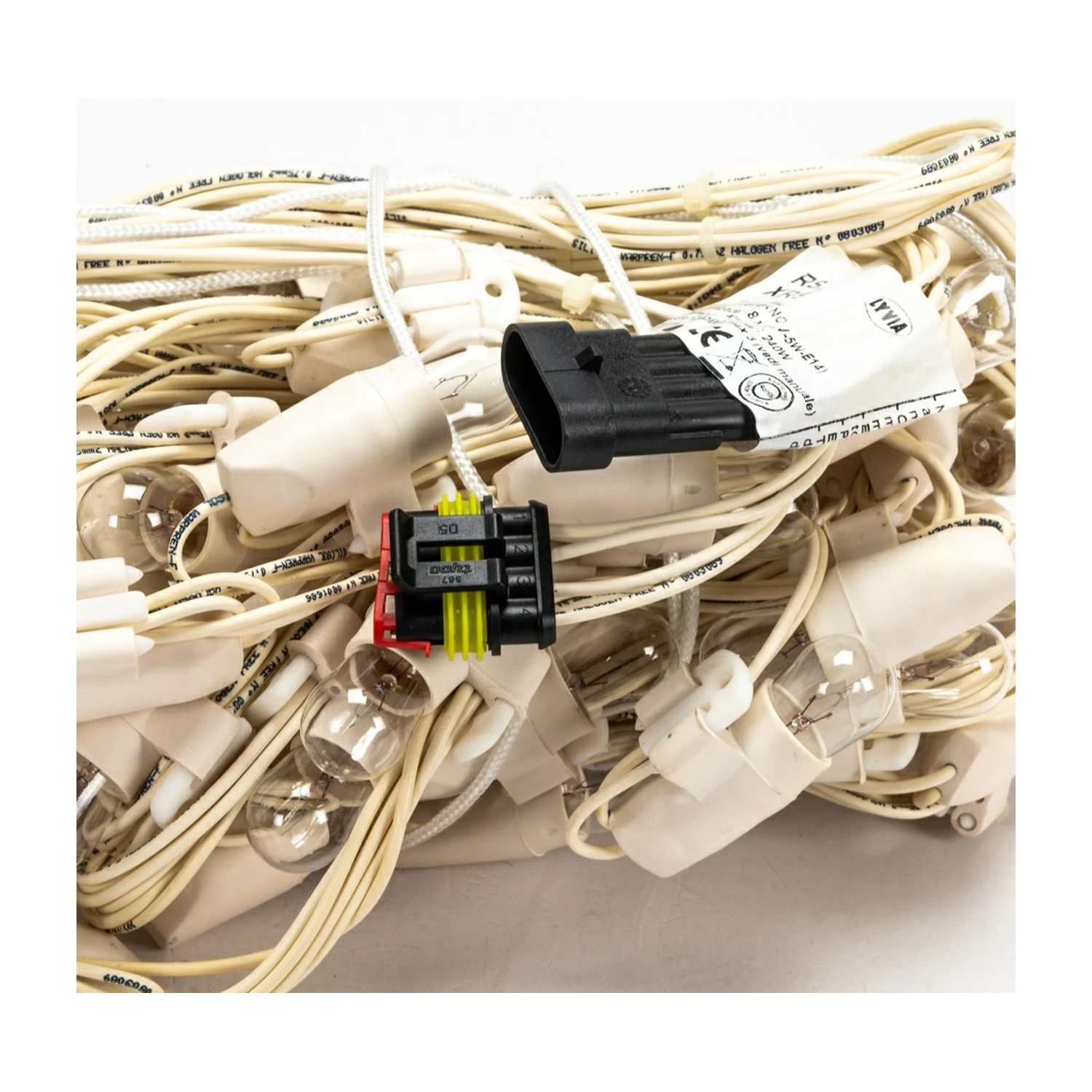 Un fascio aggrovigliato di fili elettrici bianchi e gialli, con connettori e lampadine attaccate.