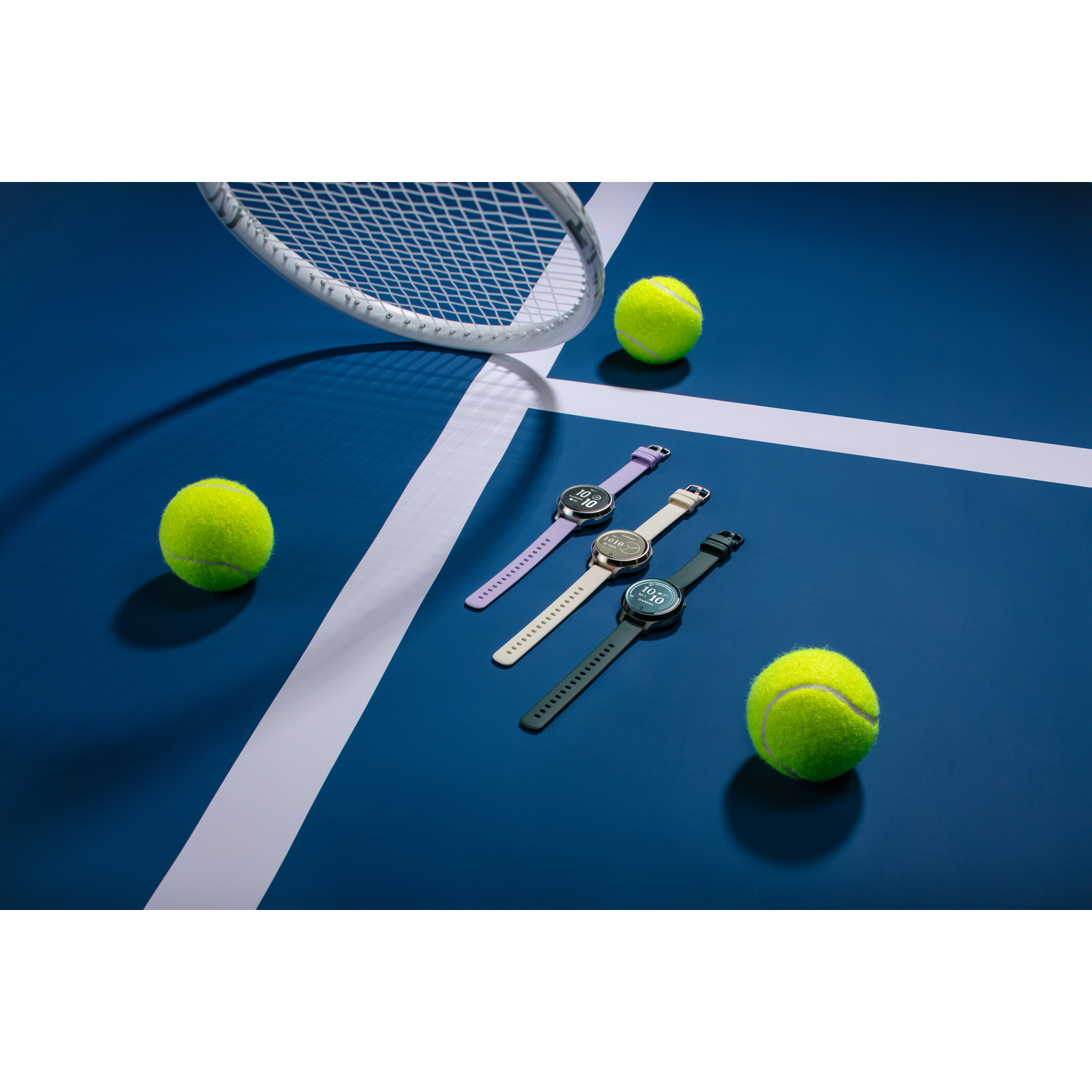 Tennisbaan met drie smartwatches. Een tennisracket en tennisballen zijn ook zichtbaar.
