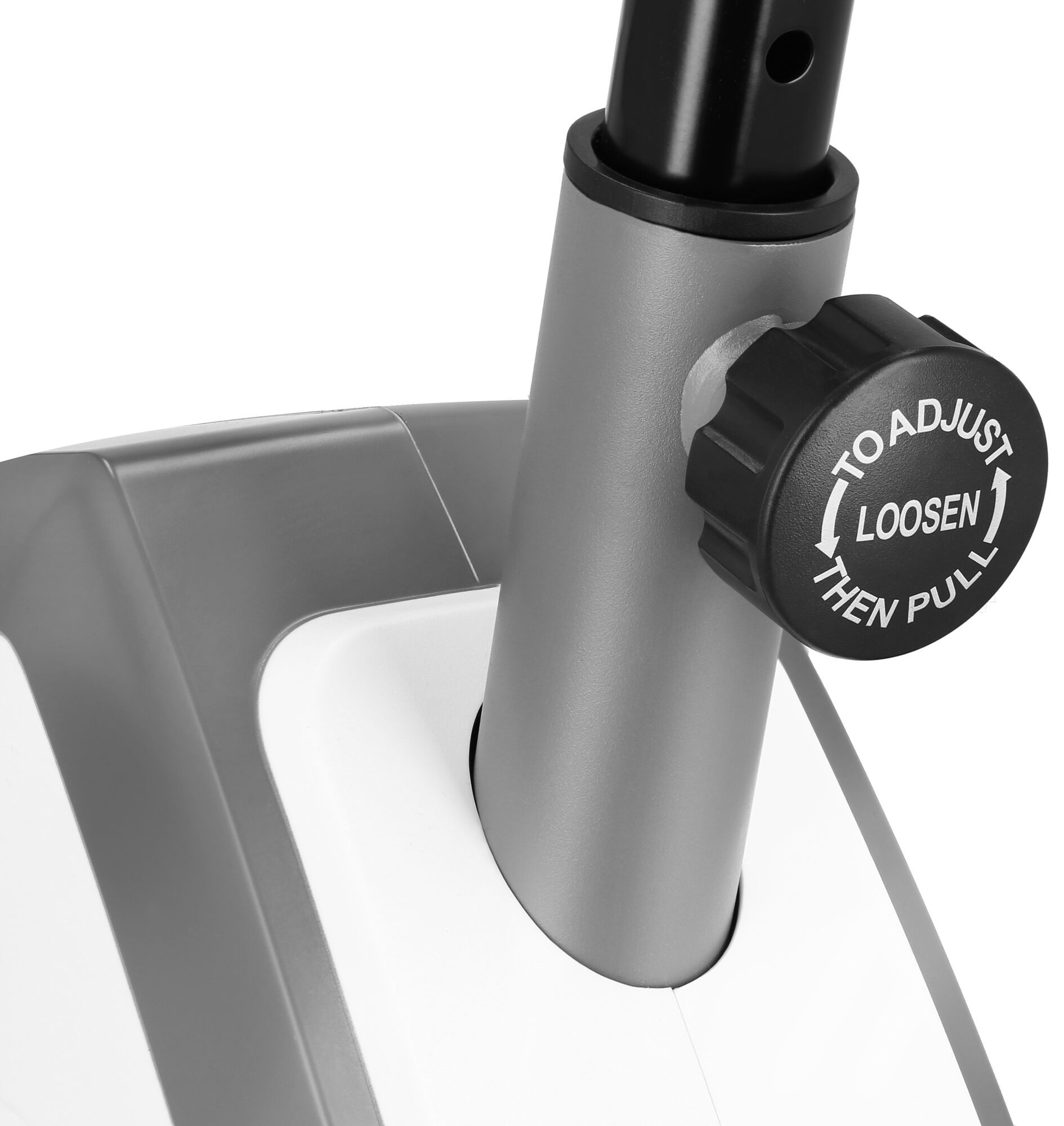 Zbliżenie pokrętła regulacji roweru treningowego. Widnieje na nim napis 'ADJUST LOOSEN THEN PULL'.
