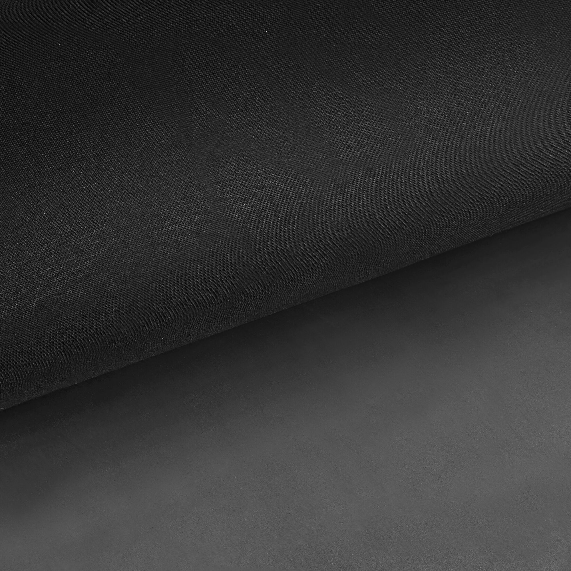 Dwie czarne próbki materiału, jedna złożona na drugiej. Górna warstwa jest przerzucona przez dolną.