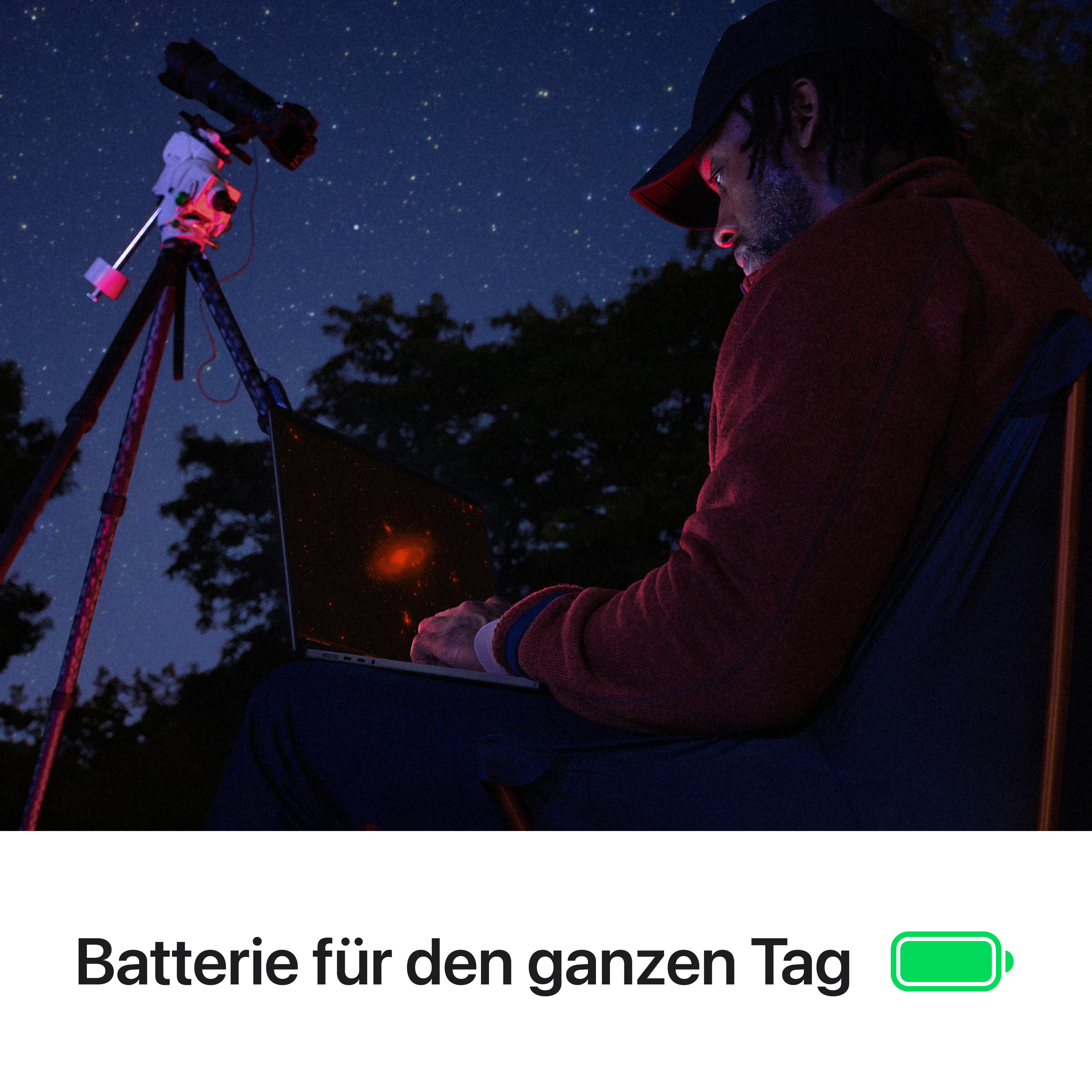 Mann benutzt Laptop, Teleskop im Hintergrund, Nachthimmel. Akku-Symbol voll. Akku für den ganzen Tag.