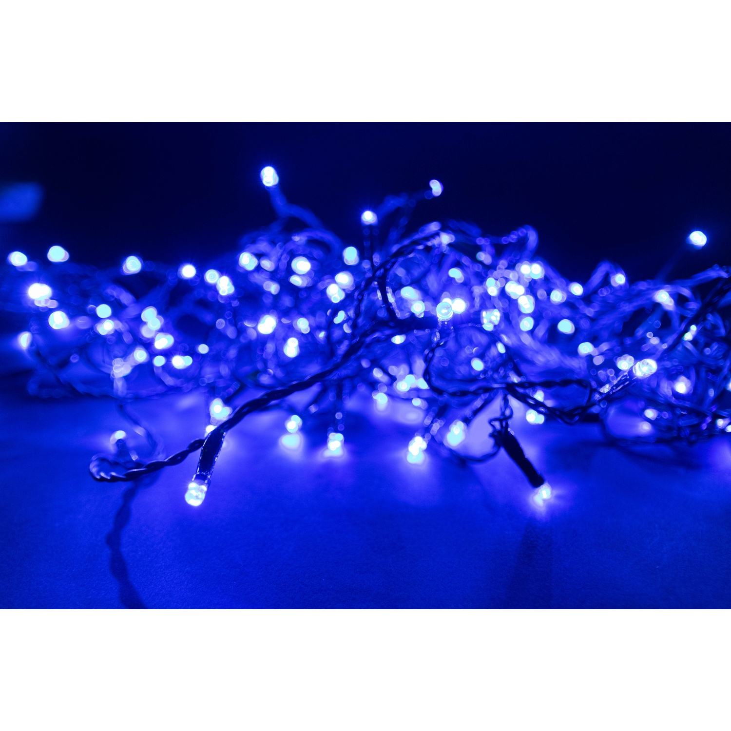 Un groviglio di luci LED blu, primo piano. Le luci sono luminose su uno sfondo blu scuro.