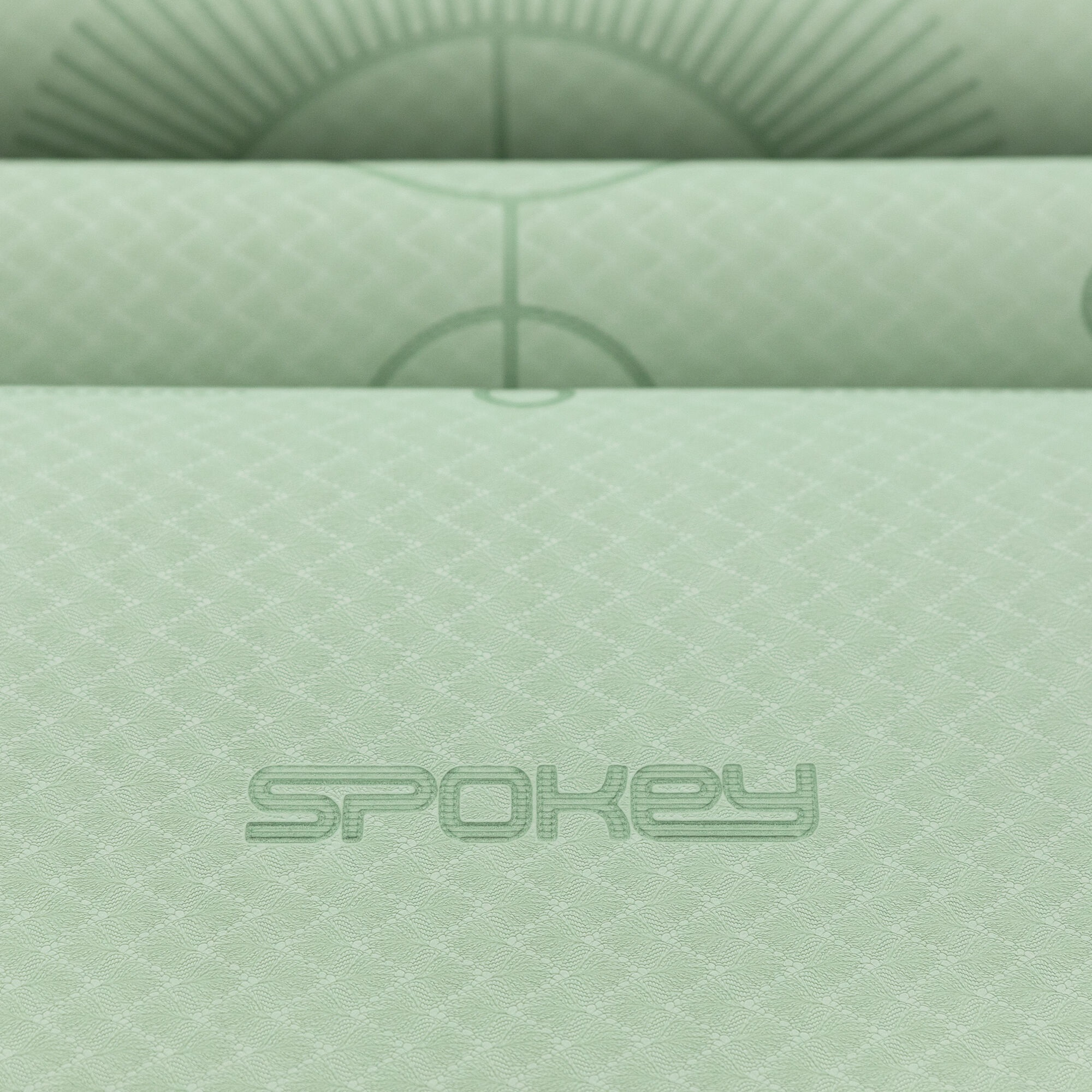 Jasnozielona mata do jogi jest zwinięta. Widoczna jest nazwa marki 'Spokey'.