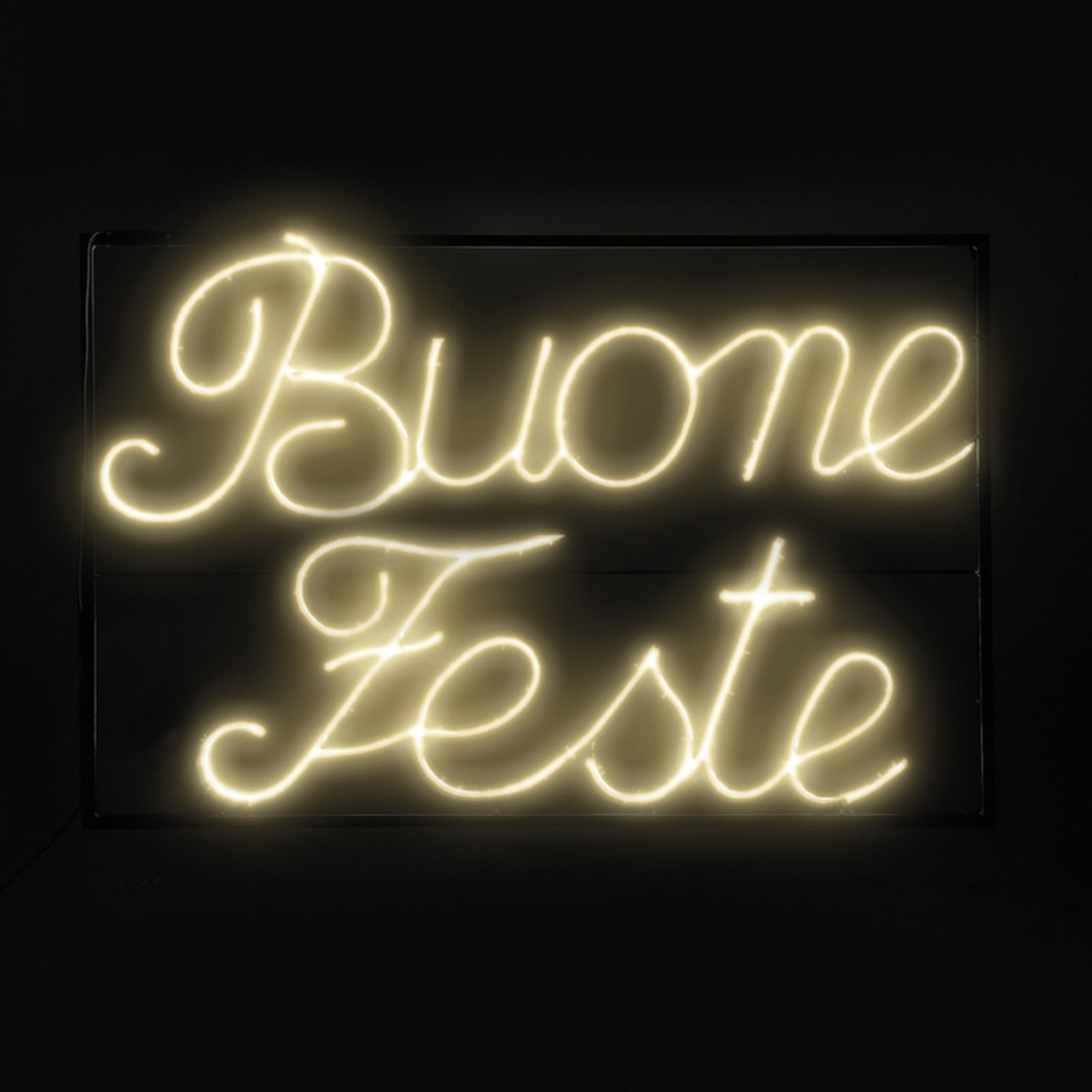 Un'insegna al neon che dice "Buone Feste" in corsivo, su uno sfondo nero.