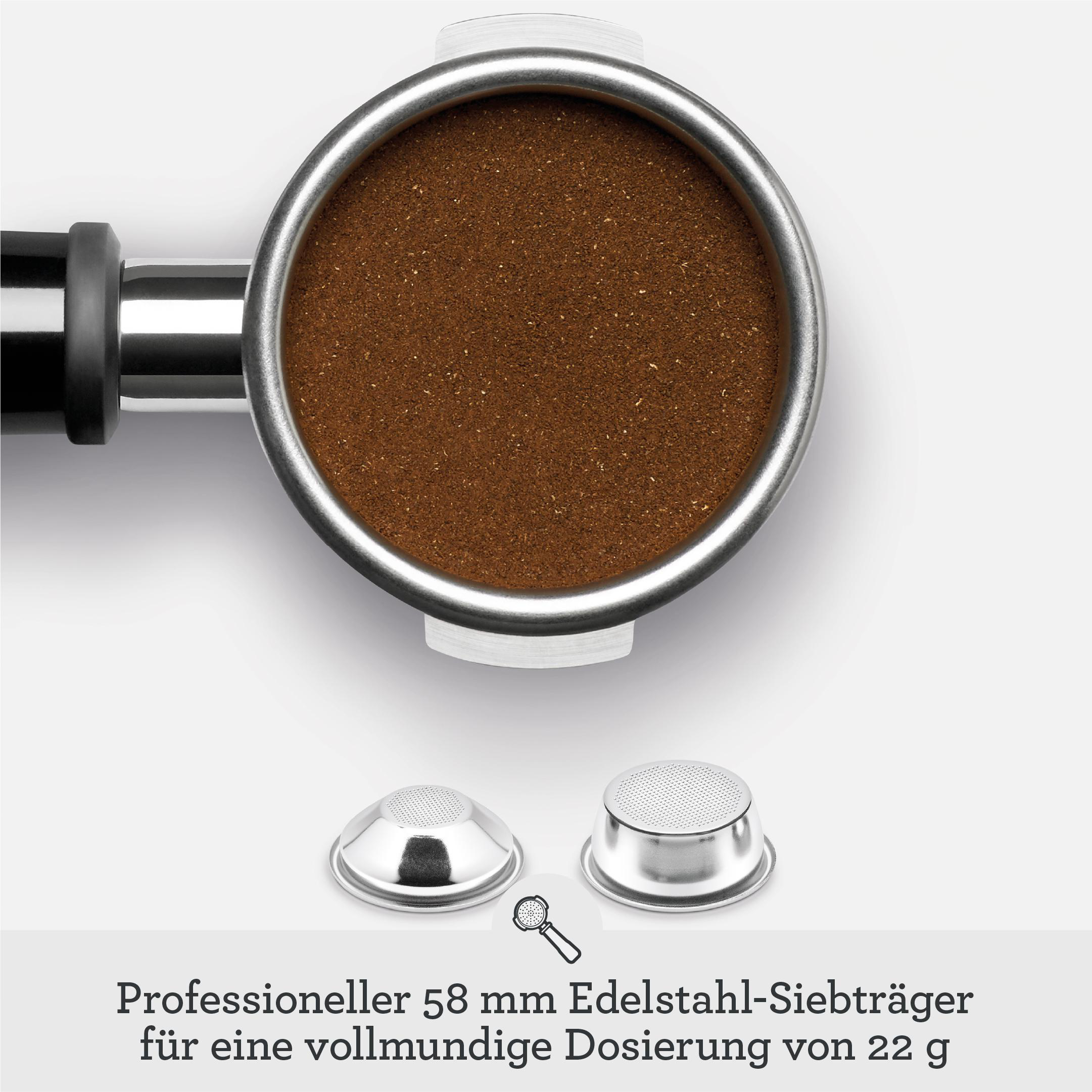 Siebträger einer Espressomaschine mit Kaffeepulver und zwei Filterkörben auf weißer Oberfläche.