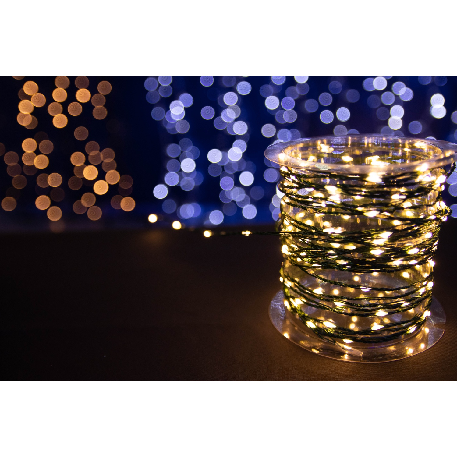 Luci di stringa su una bobina. Lo sfondo presenta luci blu e oro sfocate.