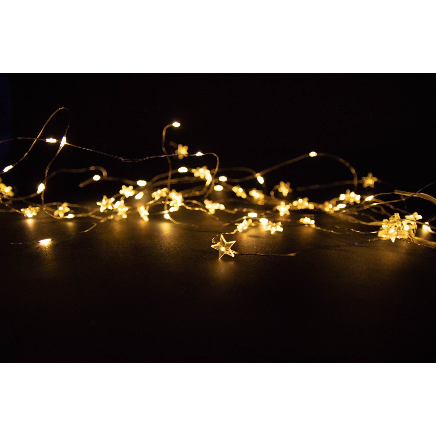 Catena di luci con stelle su sfondo nero.