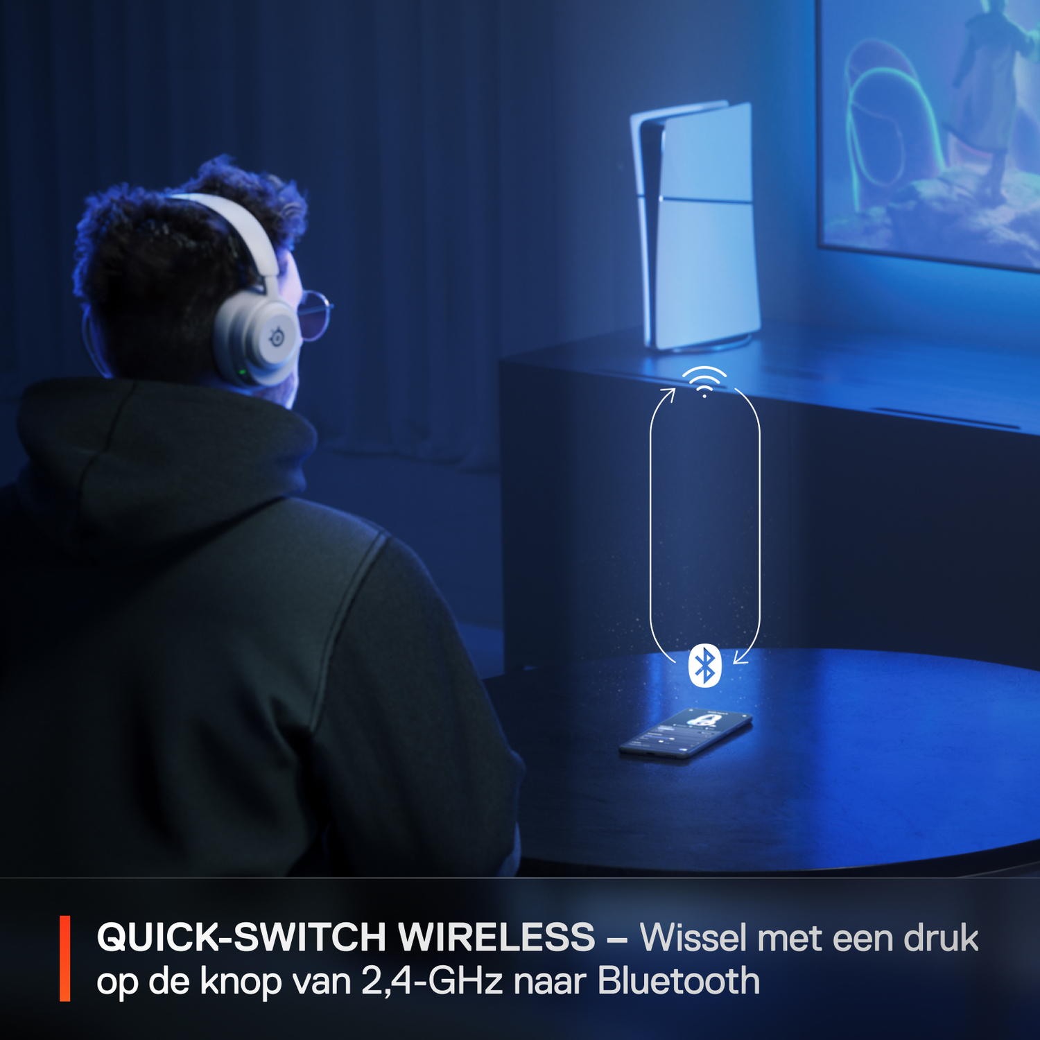 Een man met koptelefoon en bril gebruikt een telefoon, console rechts.