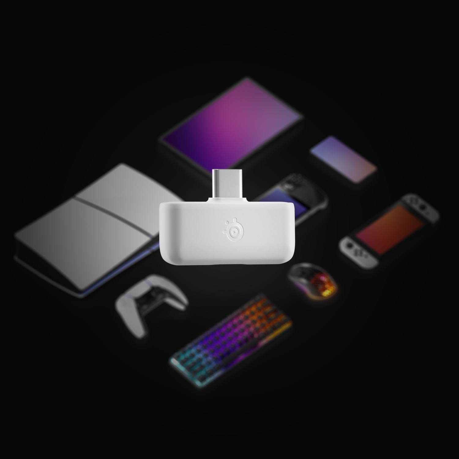 Un adaptateur blanc est entouré de divers appareils, comme une console, un téléphone et une manette, sur une surface noire.