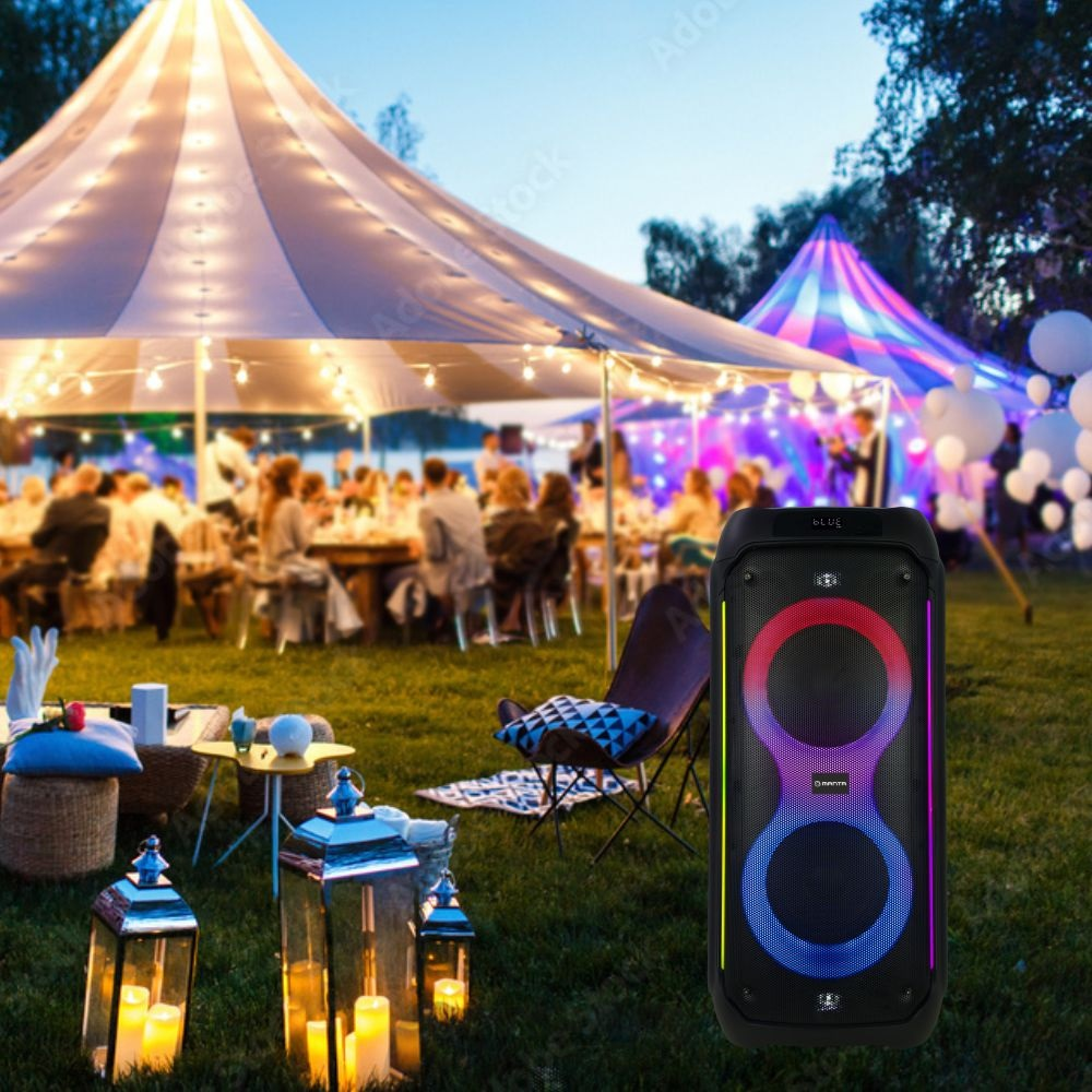 Impreza plenerowa: Ludzie zgromadzeni pod namiotem z głośnikiem na trawie.