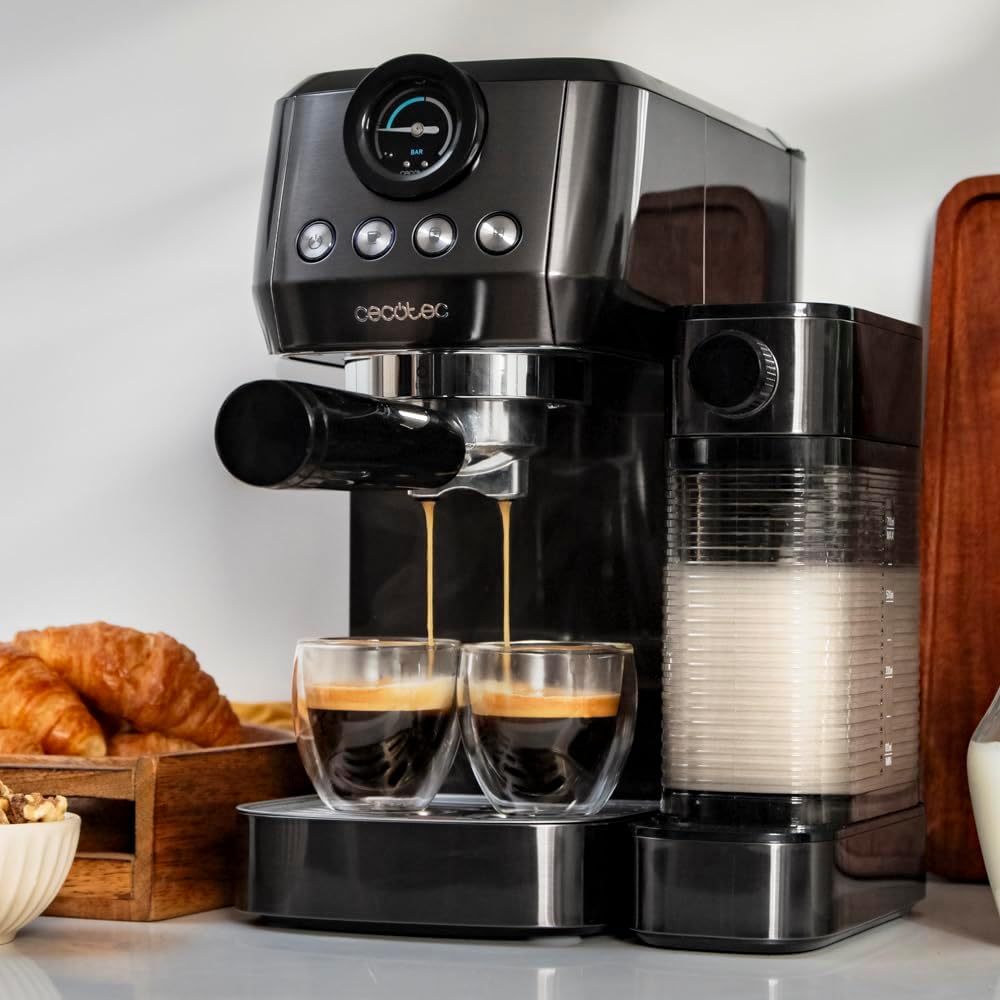 Egy eszpresszó gép, amely két poharat tölt. Van egy tejes edény és croissant a közelben.