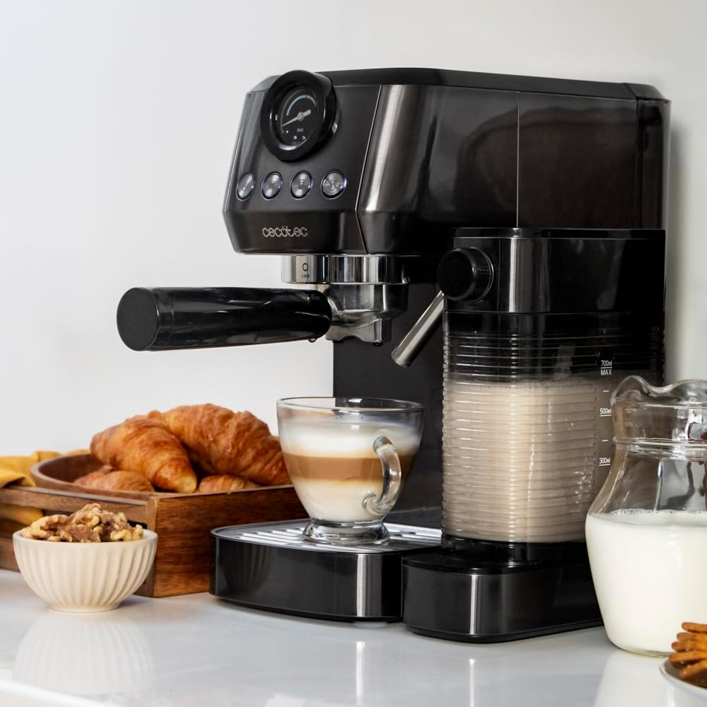 Fekete eszpresszógép latte-val, croissant-nal és tejjel.