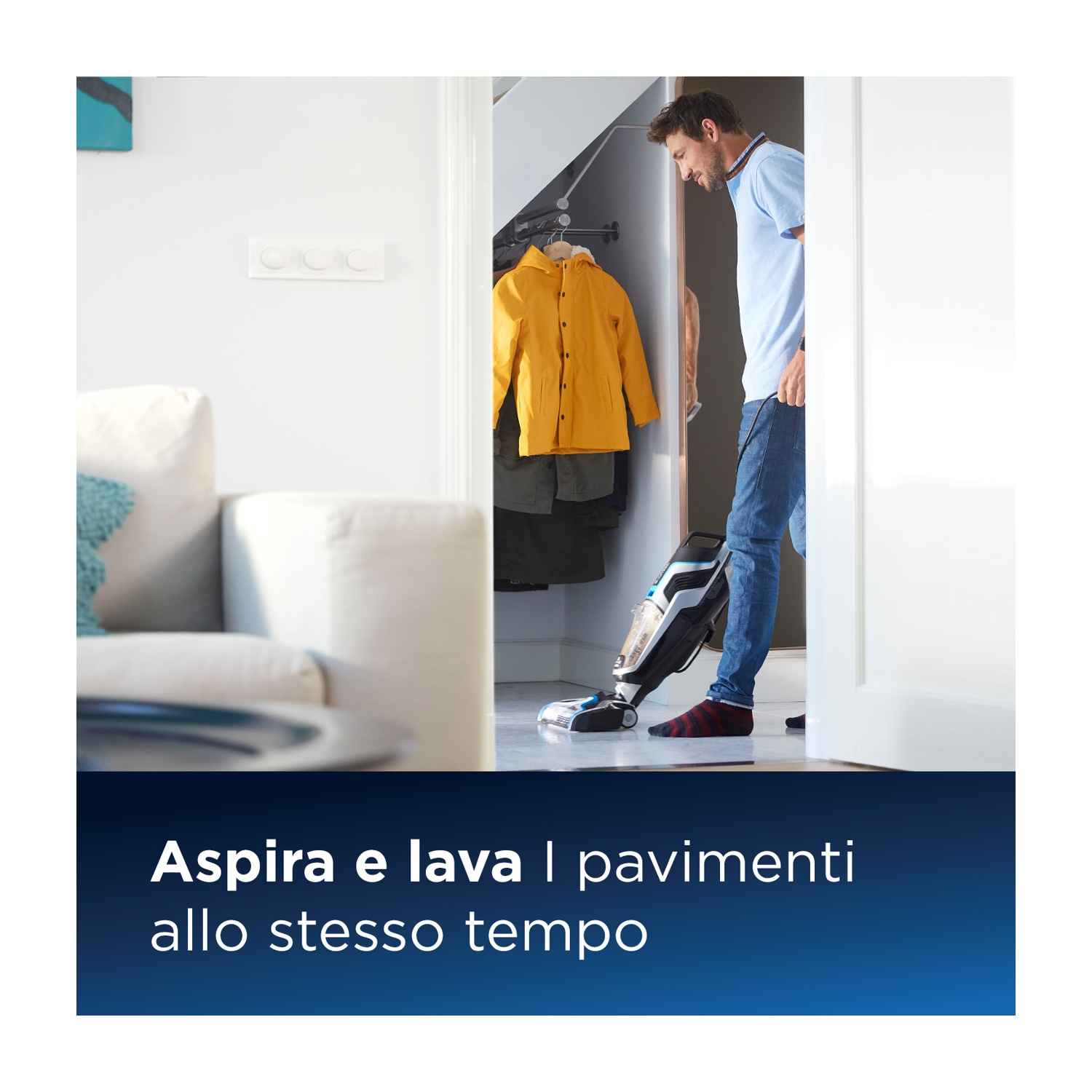 Un uomo aspira una stanza. Il testo dice: Aspira e lava i pavimenti contemporaneamente.