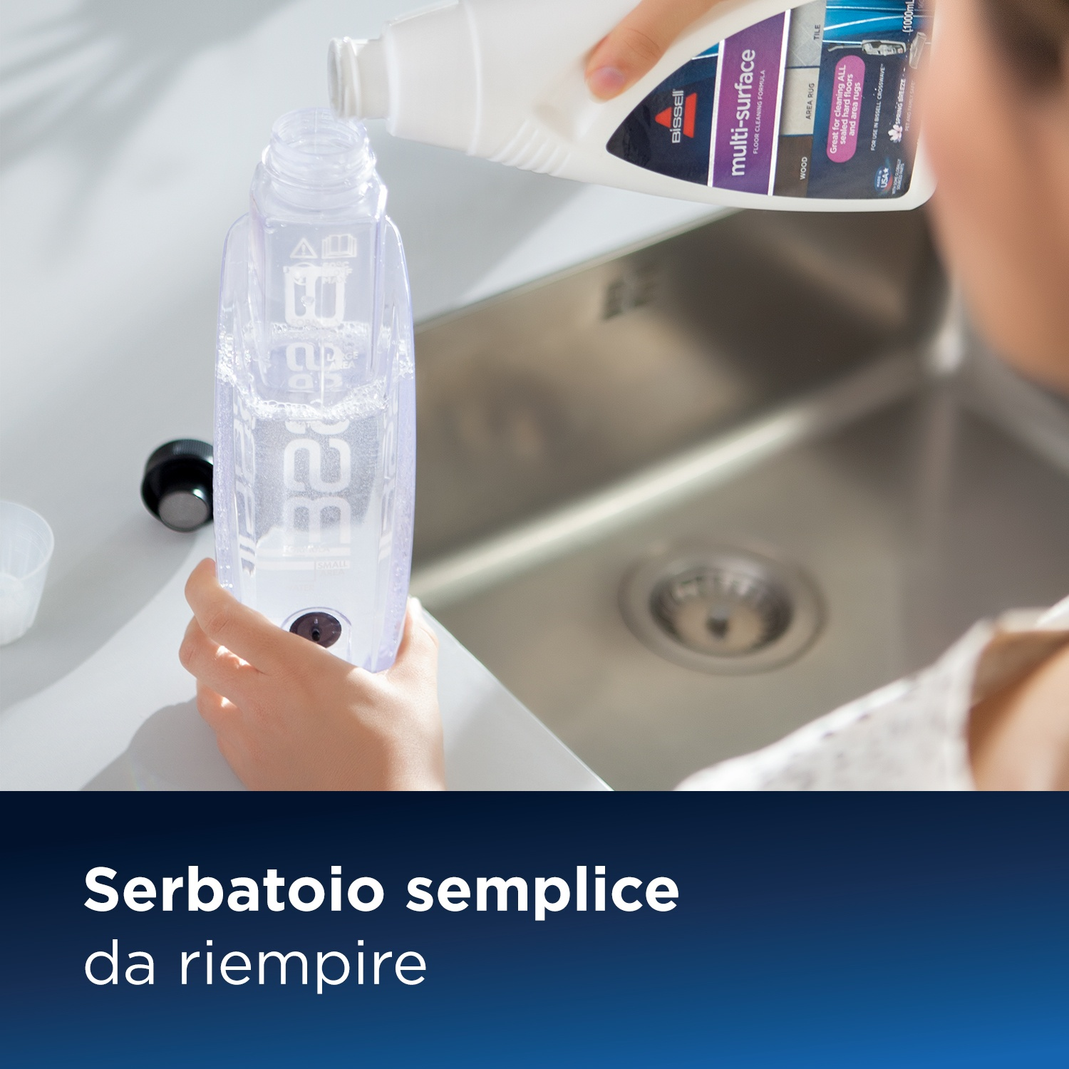 Una persona versa liquido detergente in una bottiglia trasparente in un lavandino.