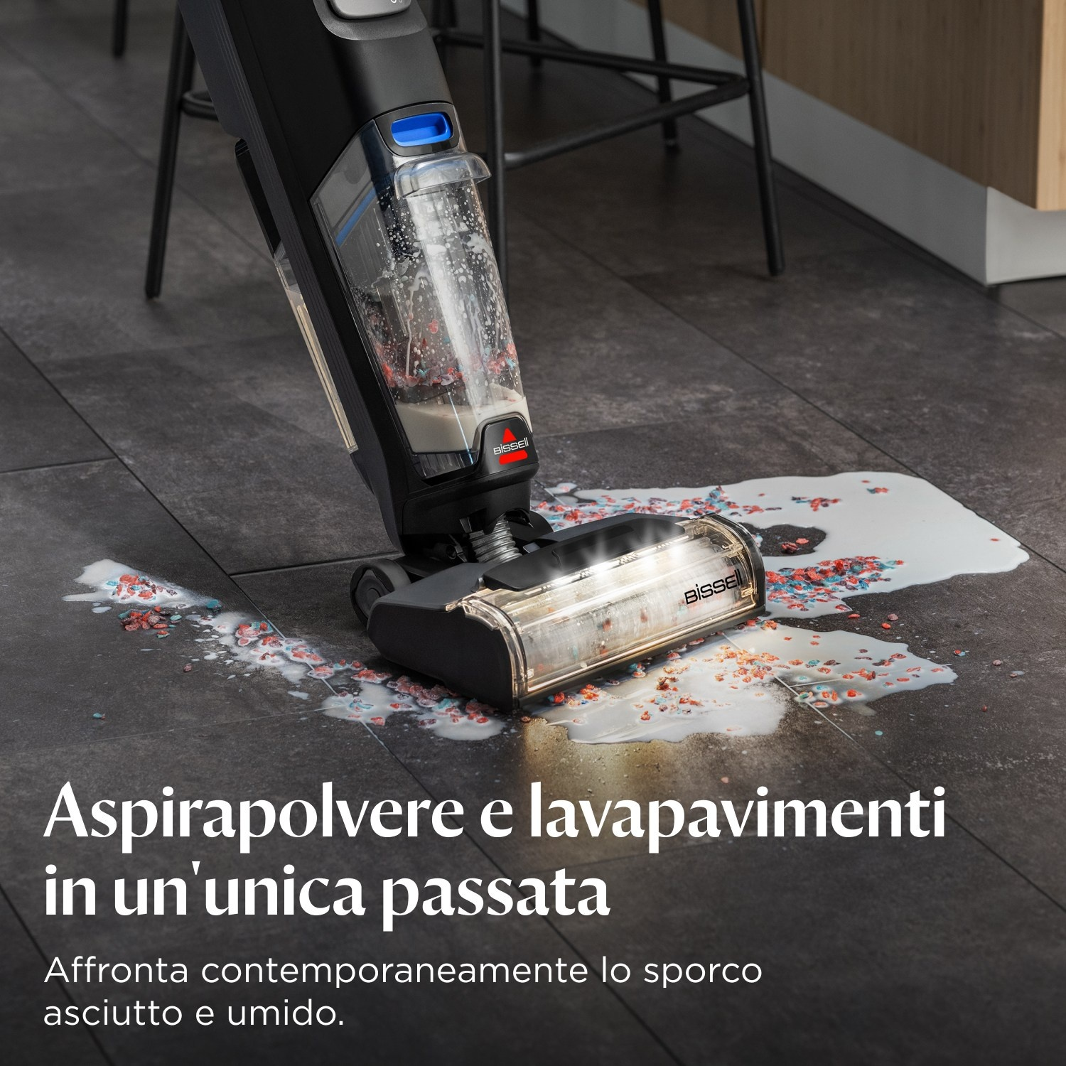 Un pulitore per pavimenti nero e blu con versamenti colorati sul pavimento.