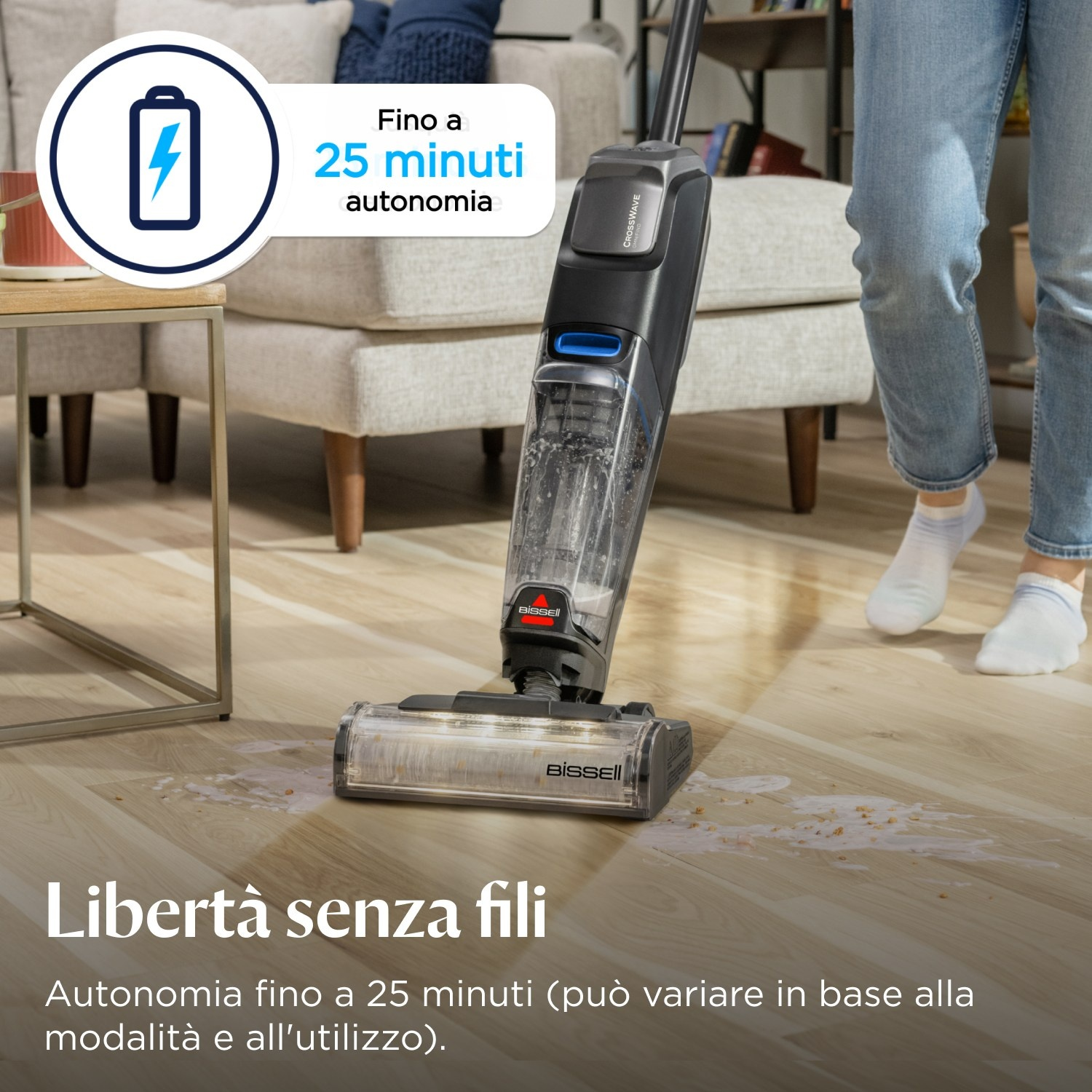 Una persona usa un aspirapolvere senza fili su un pavimento in legno.