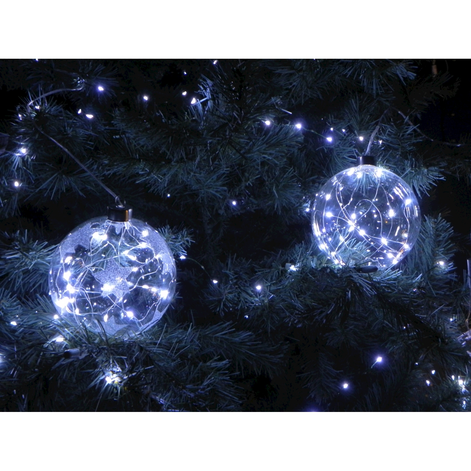 Albero di Natale con due palline luminose. Ogni pallina contiene luci bianche.