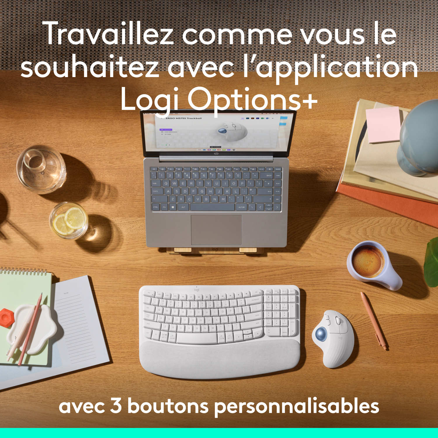 Un ordinateur portable, un clavier, une souris et des accessoires sur un bureau en bois.