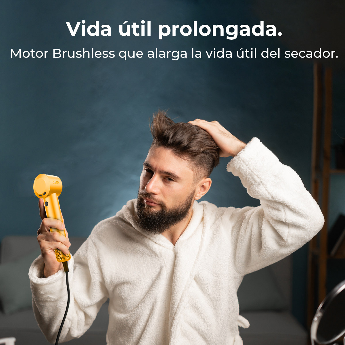 Un hombre en bata secándose el pelo con un secador amarillo.