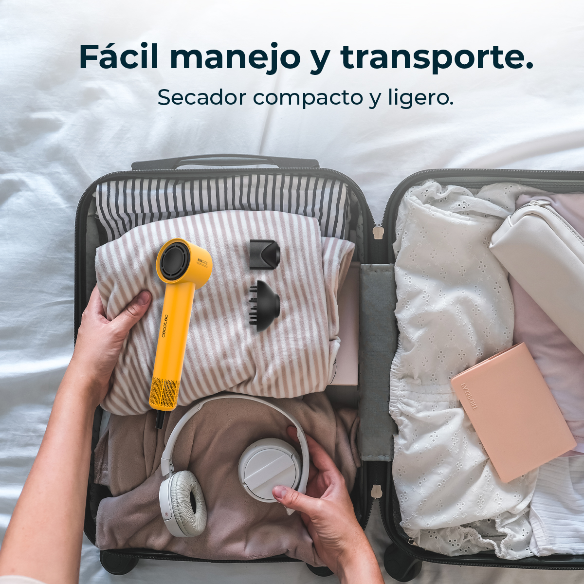 Maleta abierta con secador de pelo amarillo, accesorios y accesorios blancos.