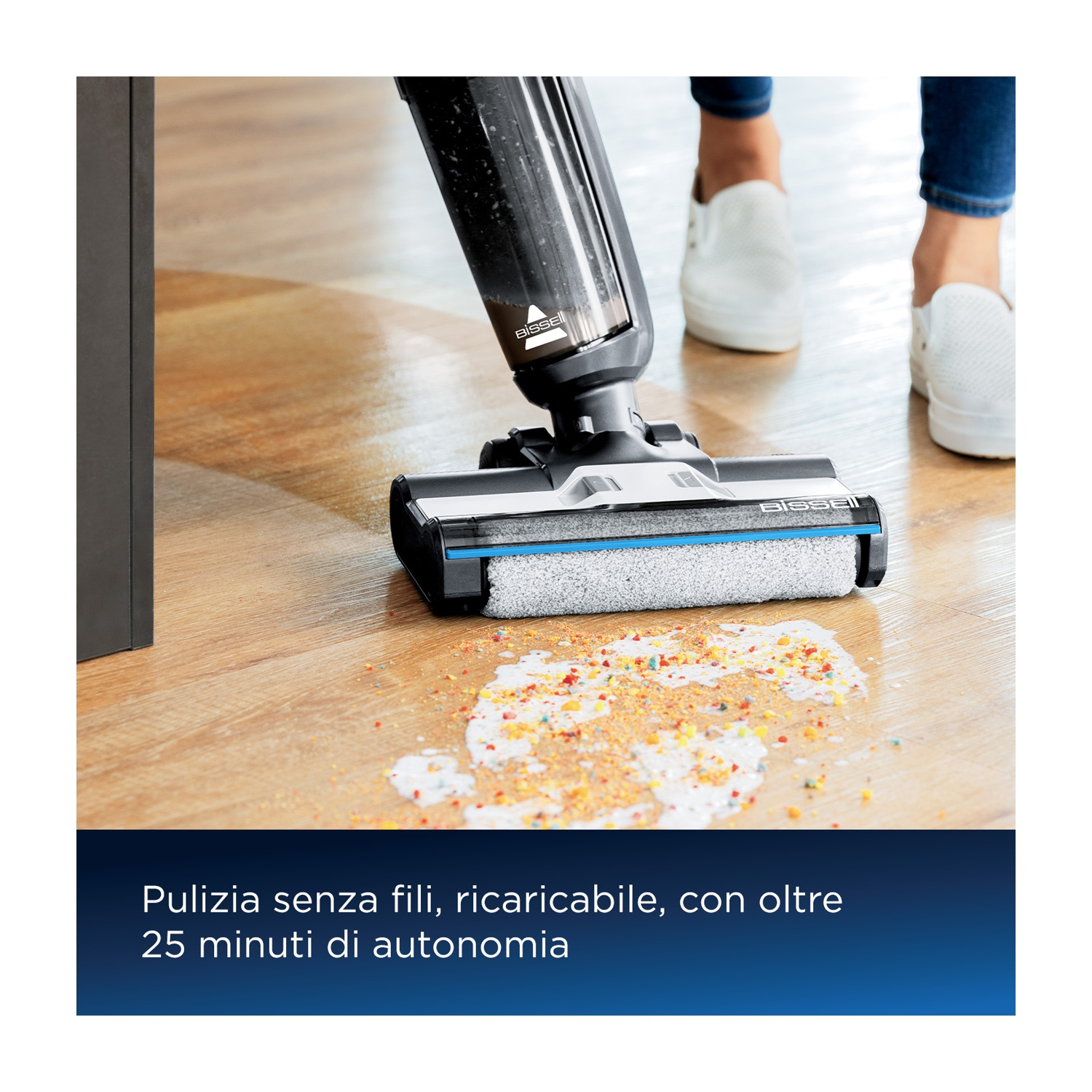 Una persona aspira un pavimento in legno con un aspirapolvere in bianco e nero, pulendo le fuoriuscite.