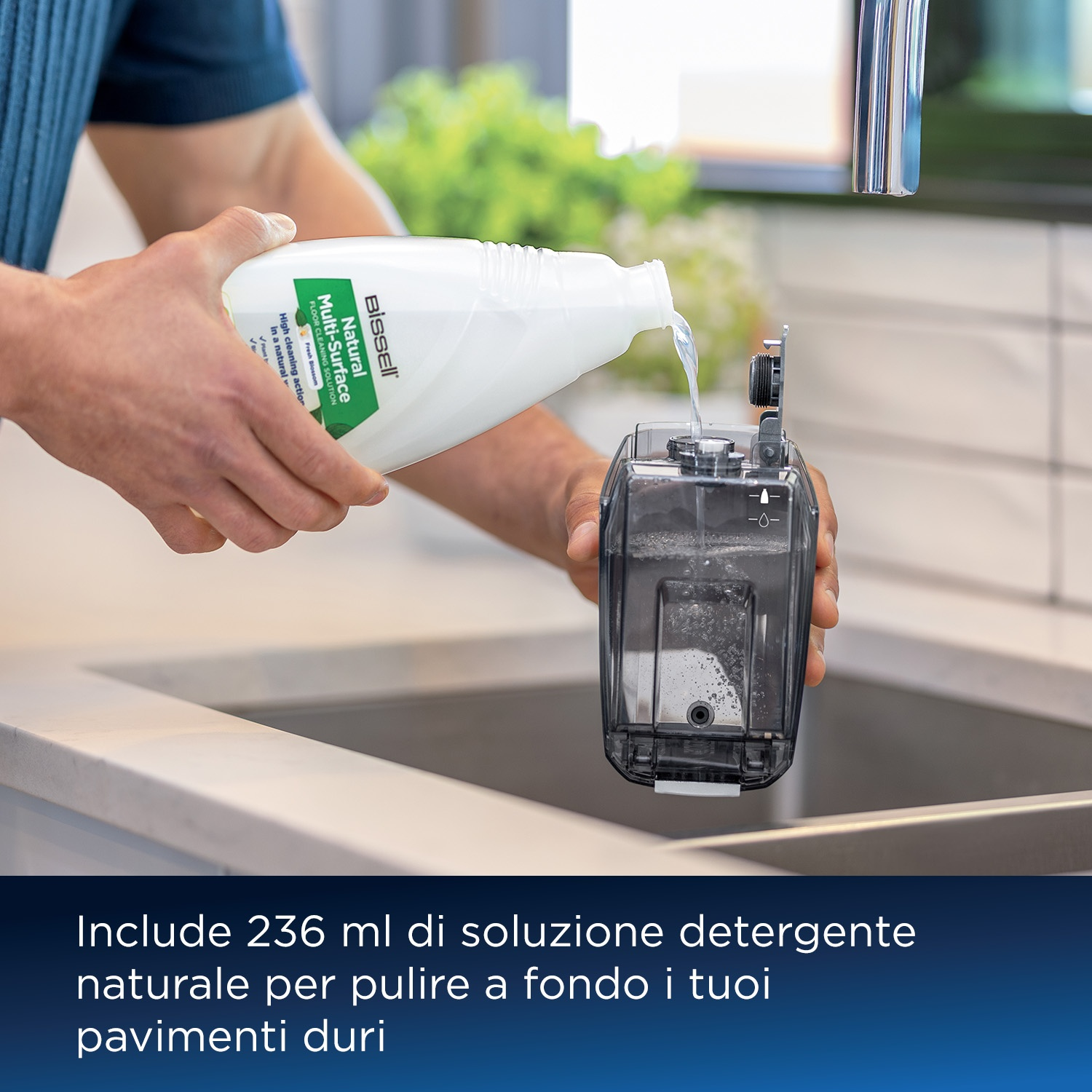 Una persona versa soluzione detergente in un elettrodomestico per la pulizia.