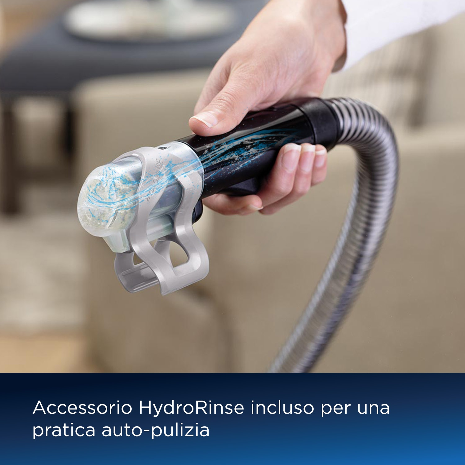 La mano di una persona tiene un accessorio per aspirapolvere con un componente di pulizia blu.