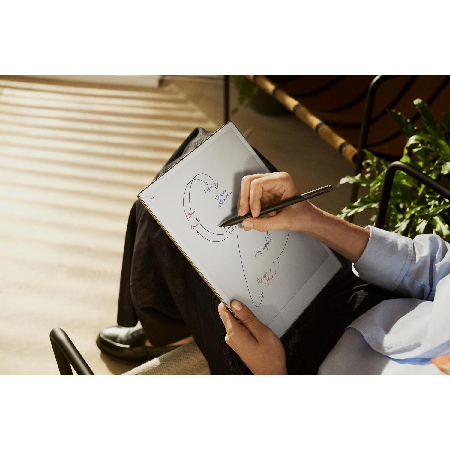 A person uses a stylus to write on a tablet.