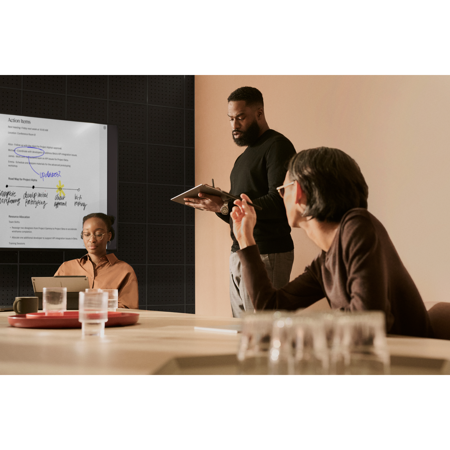 Group of people in a meeting. One person holds a notebook, presenting ideas.