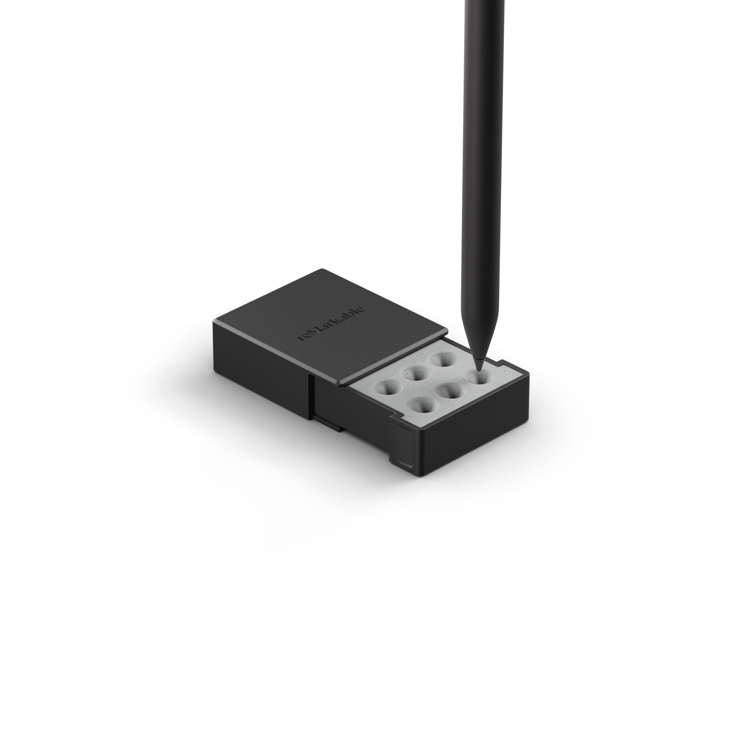 A pen is pointing towards refills inside the Remarkable pen case.